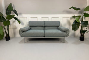 Gebrauchtes graues mint Rolf Benz Plura Designer Stoff Sofa vor einer Wand, stilvoll und modern eingerichtet.