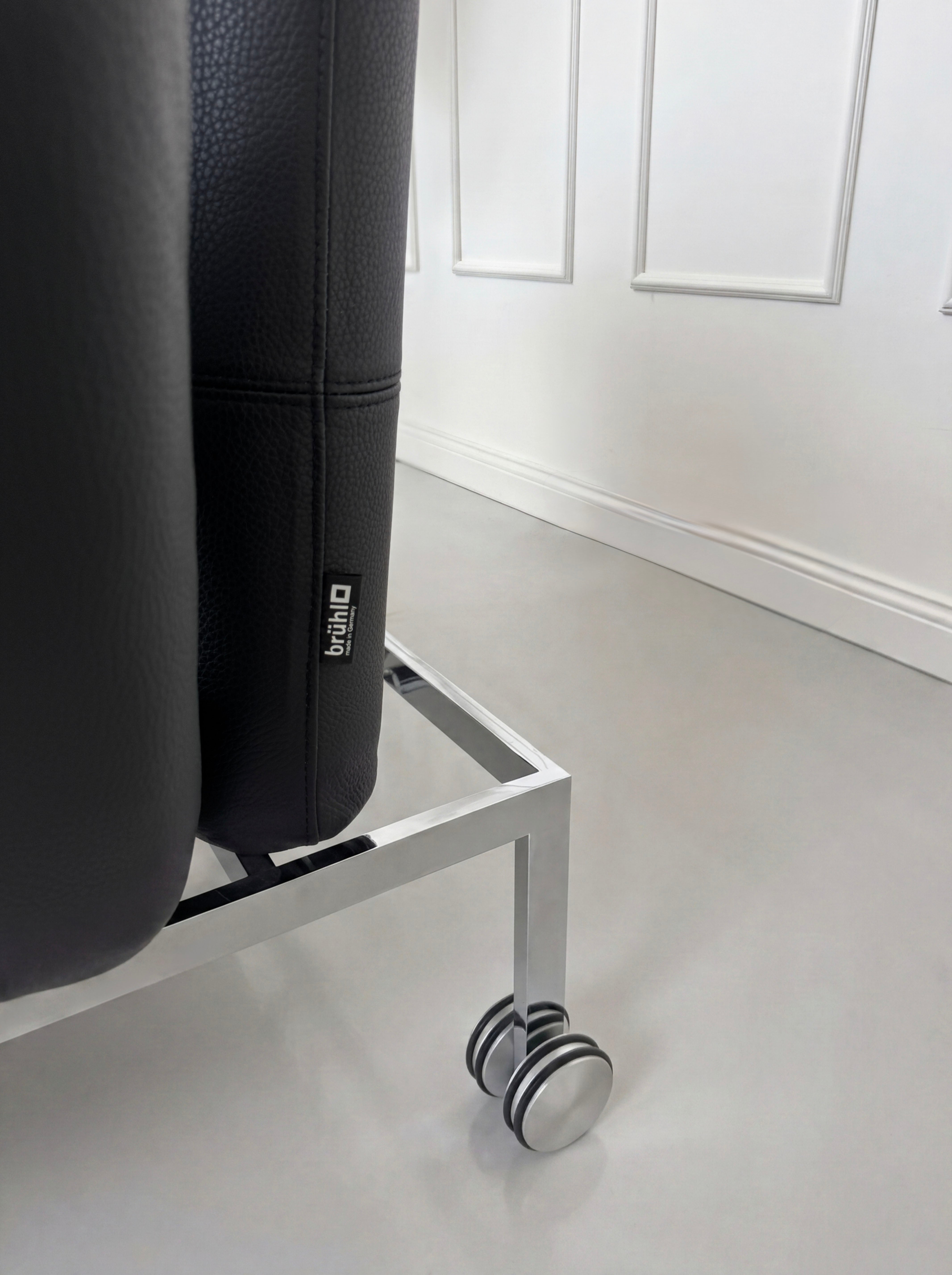 Gebrauchtes schwarzes Brühl Roro Small Designer Leder Sofa vor einer Wand, stilvoll und modern eingerichtet.