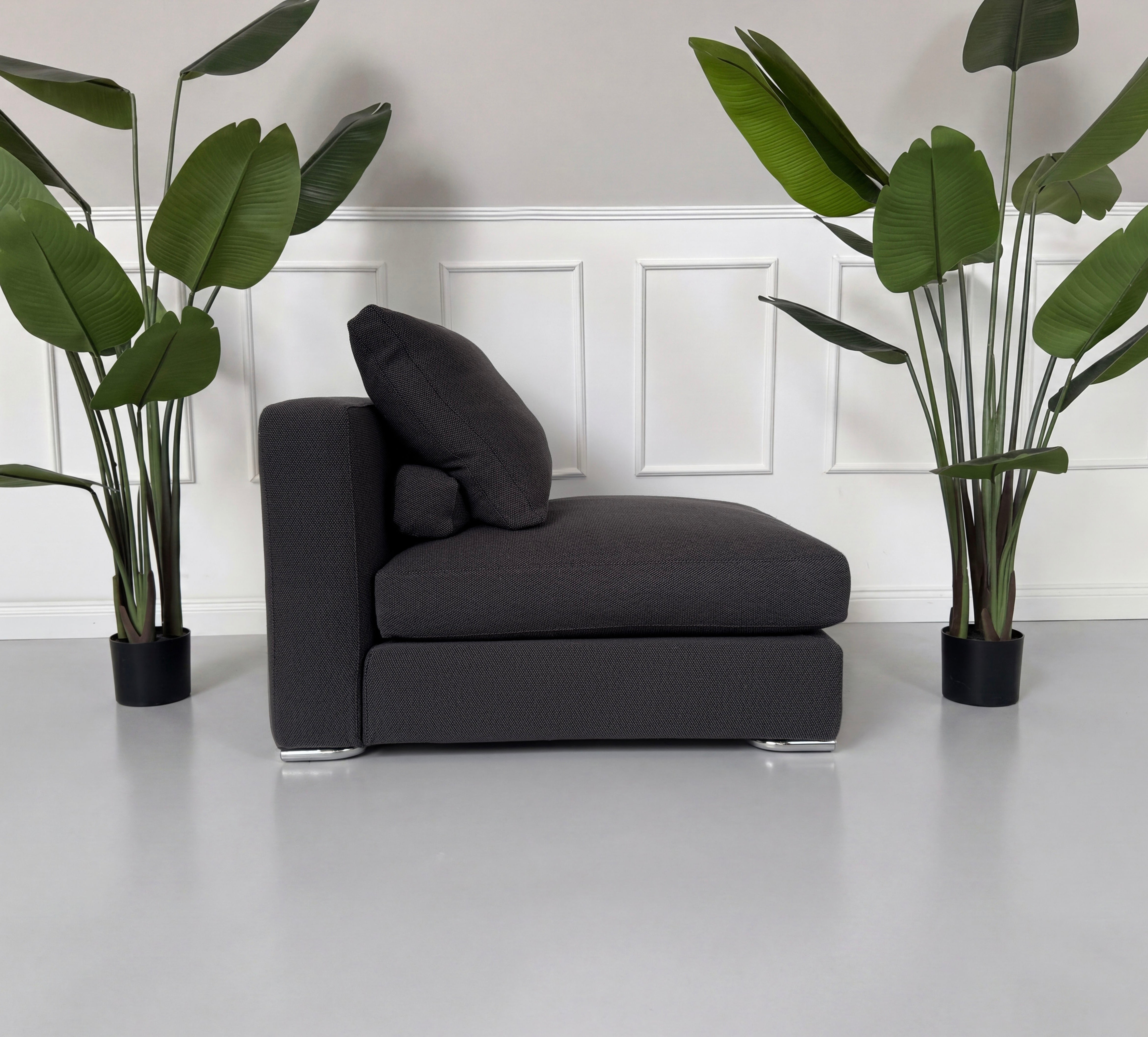 Gebrauchter Minotti Jagger Sessel Designer Stoff Sofa vor einer Wand, stilvoll und modern eingerichtet.
