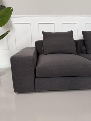 Gebrauchtes graues Minotti Jagger Designer Stoff Sofa vor einer Wand, stilvoll und modern eingerichtet.