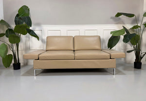 Gebrauchtes beiges Brühl Alba Designer Leder Sofa vor einer Wand, stilvoll und modern eingerichtet.