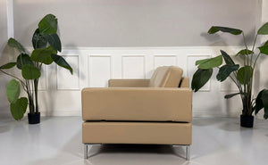 Gebrauchtes beiges Brühl Alba Designer Leder Sofa vor einer Wand, stilvoll und modern eingerichtet.