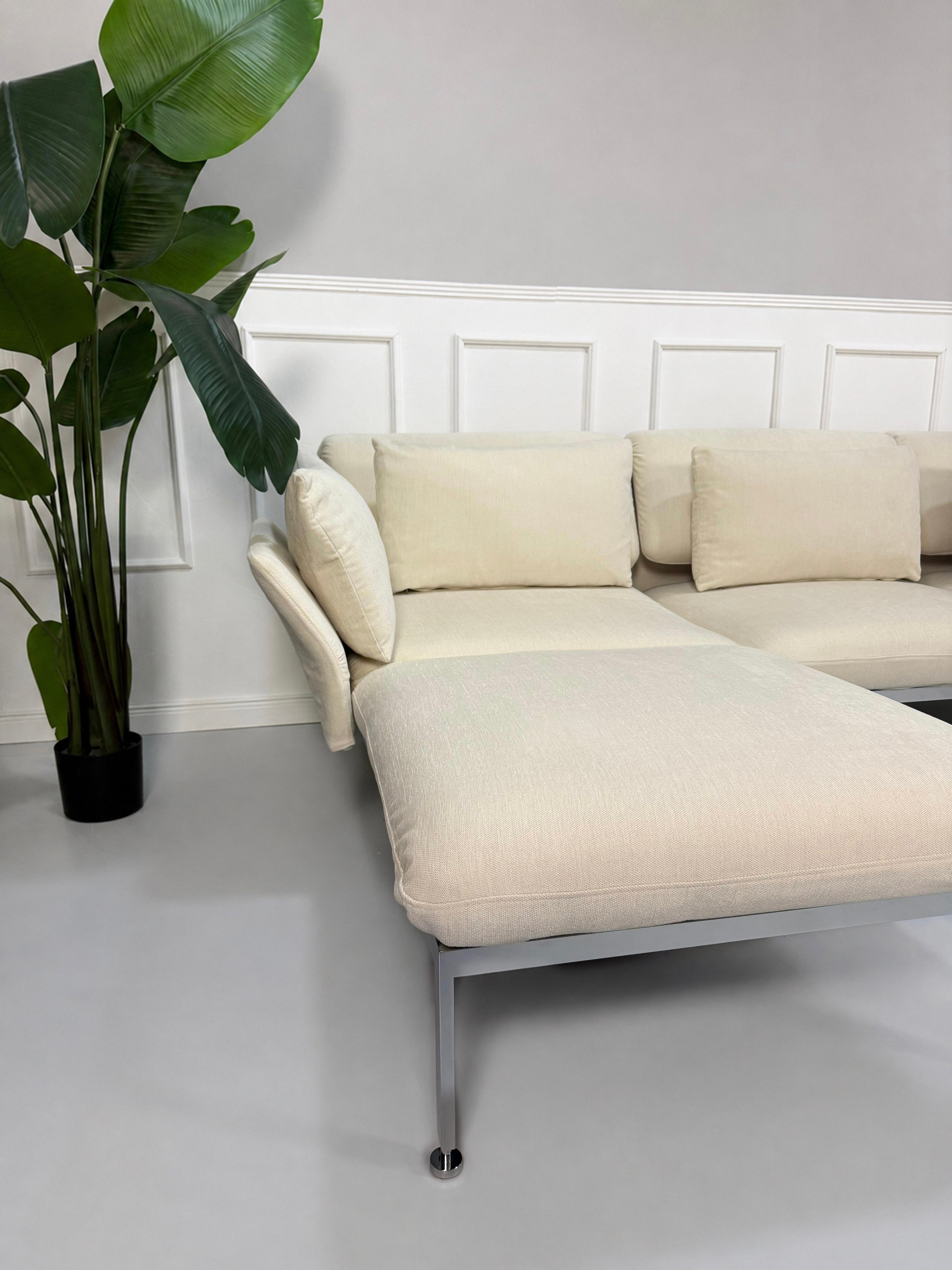 Gebrauchtes beiges Brühl Roro Designer Stoff Ecksofa vor einer Wand, stilvoll und modern eingerichtet.