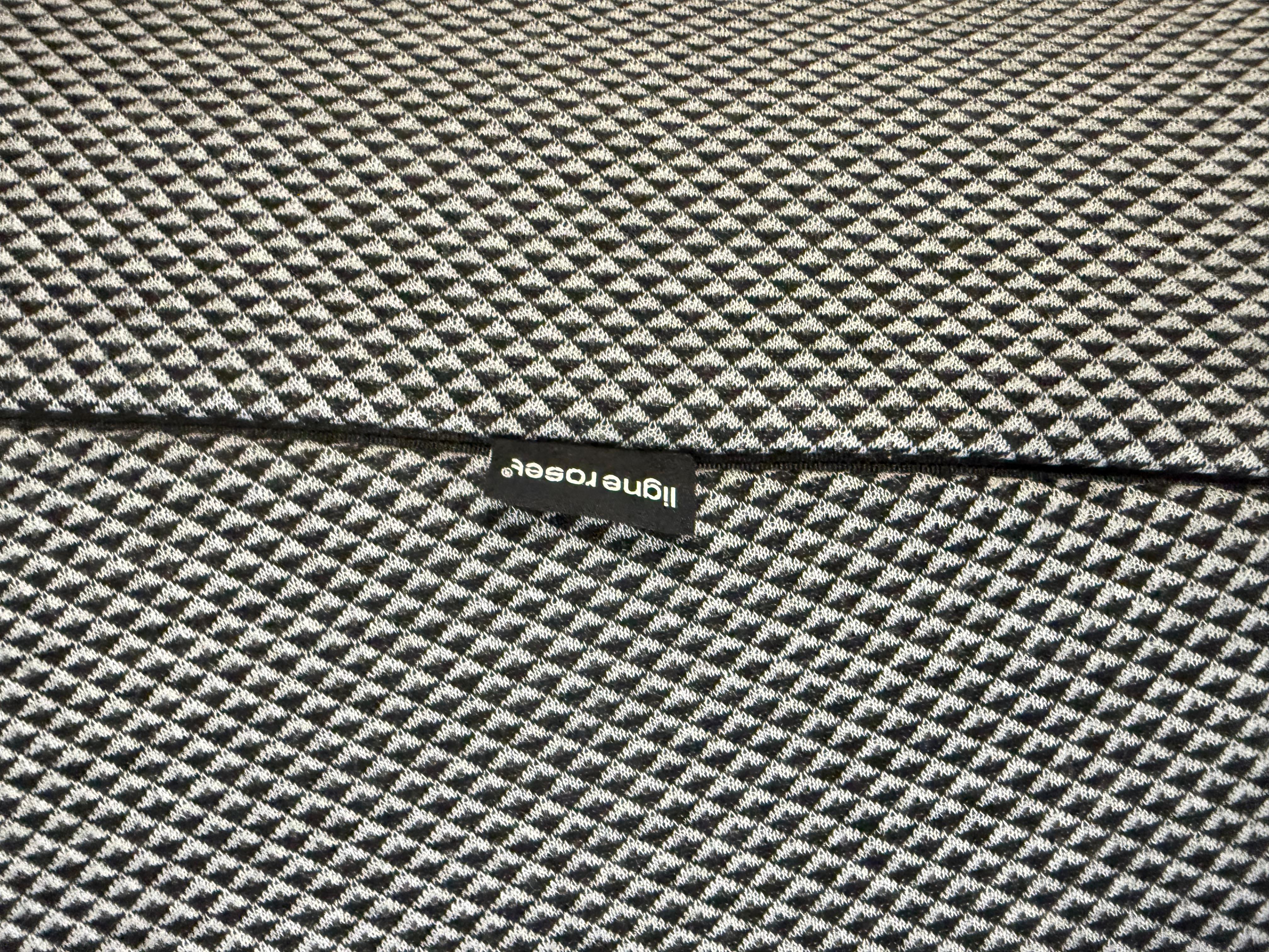 Gebrauchtes graues Ligne Roset Designer Stoff Sofa vor einer Wand, stilvoll und modern eingerichtet.