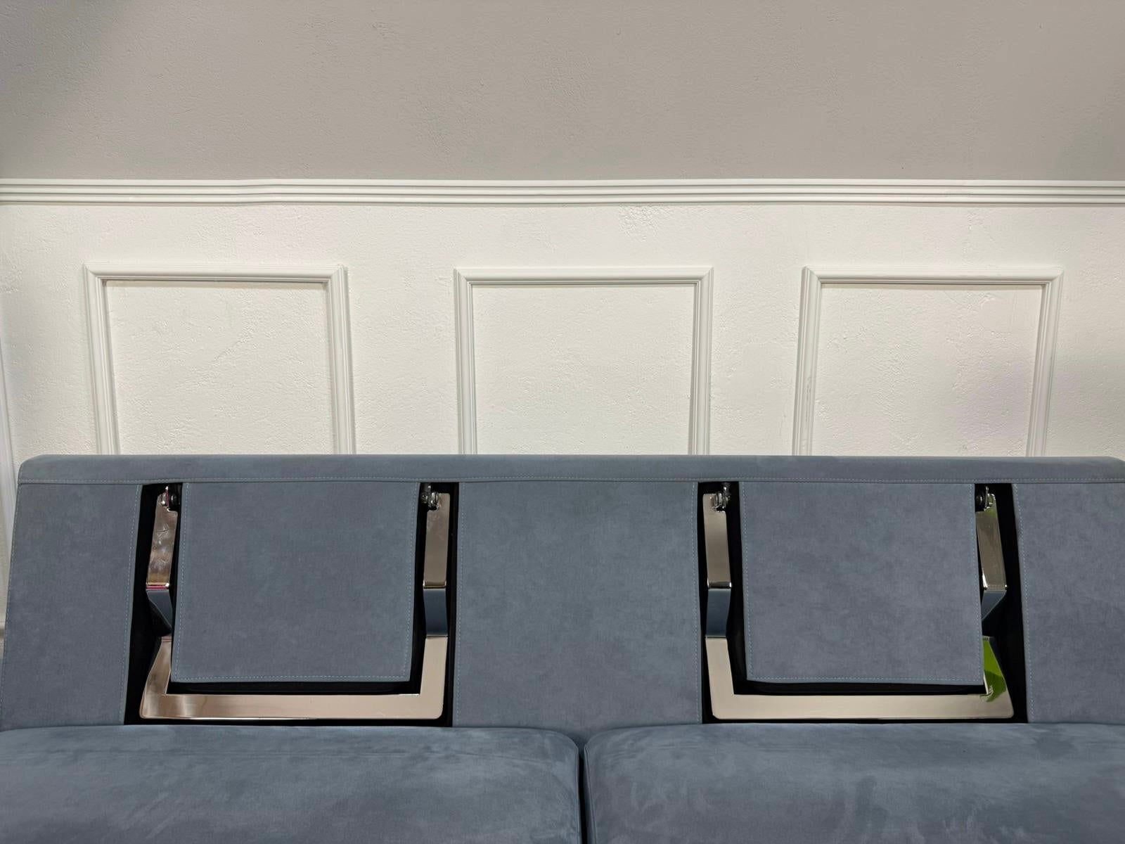 Gebrauchtes blaues Brühl Alba Designer Stoff Sofa vor einer Wand, stilvoll und modern eingerichtet.