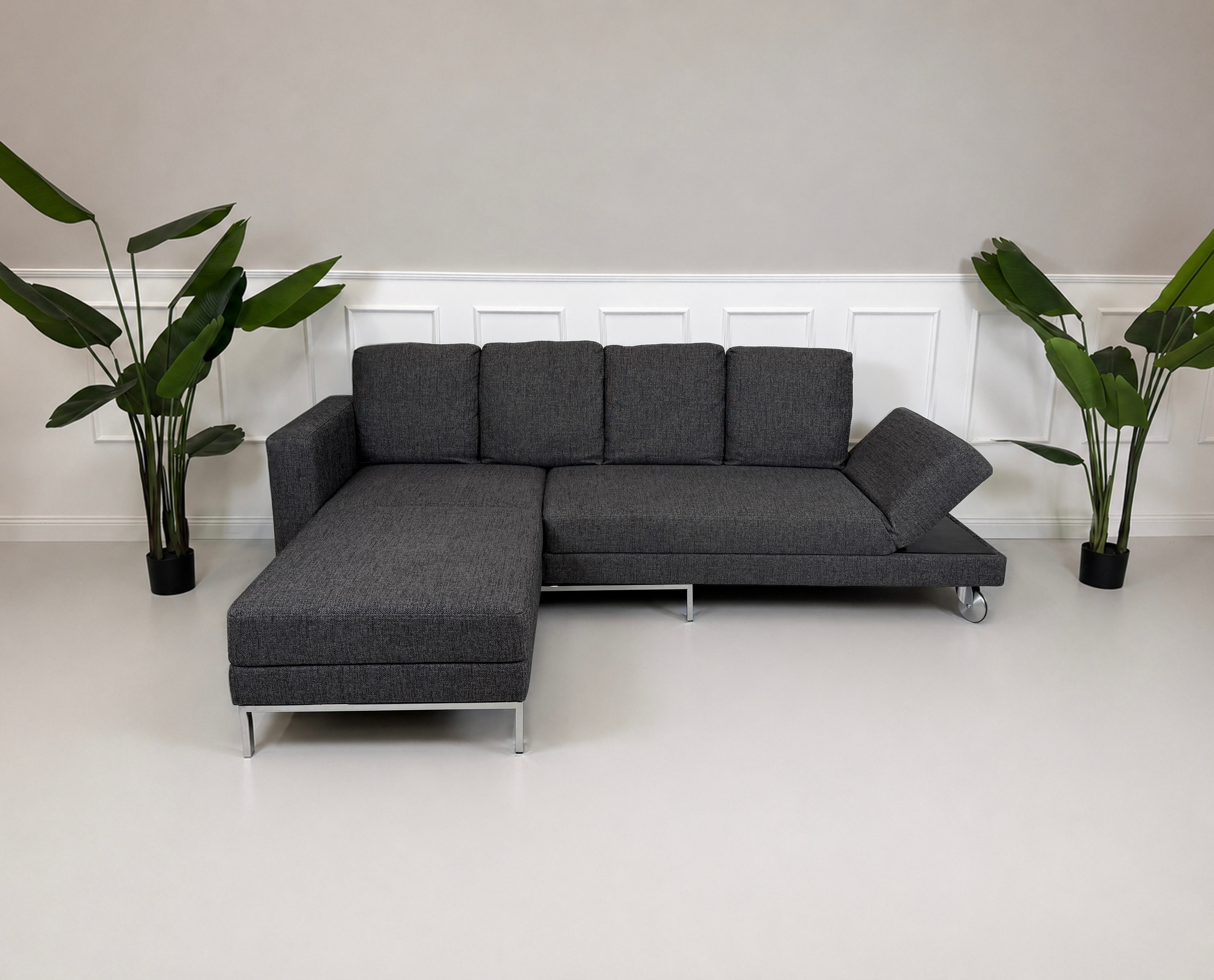 Gebrauchtes graues Brühl Four Two Designer Stoff Sofa vor einer Wand, stilvoll und modern eingerichtet.