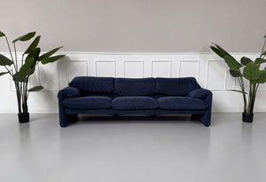 Gebrauchtes blaues Cassina Maralunga Designer Stoff Sofa vor einer Wand, stilvoll und modern eingerichtet.
