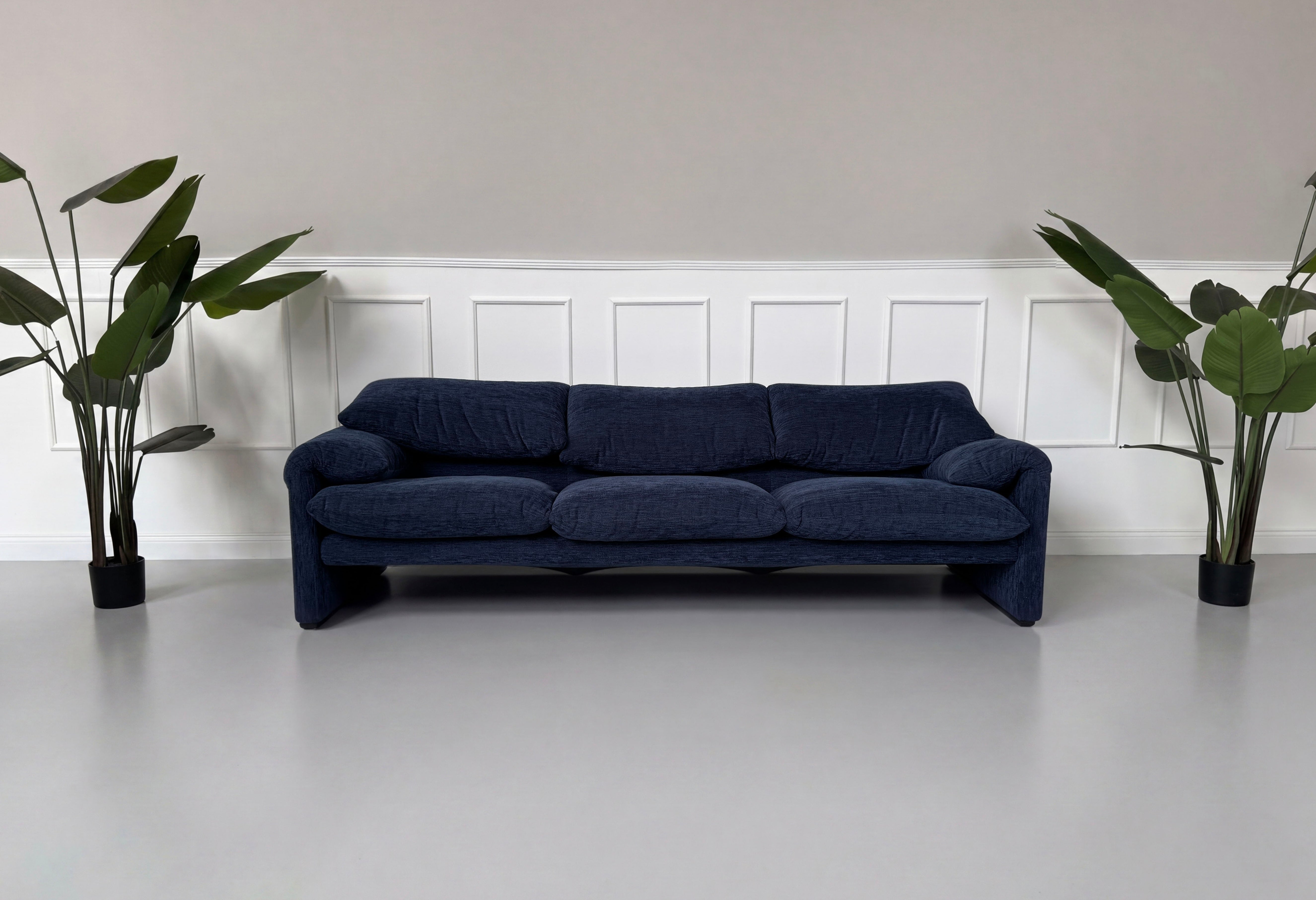 Gebrauchtes blaues Cassina Maralunga Designer Stoff Sofa vor einer Wand, stilvoll und modern eingerichtet.
