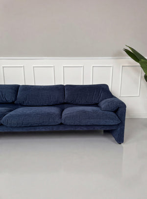 Gebrauchtes blaues Cassina Maralunga Designer Stoff Sofa vor einer Wand, stilvoll und modern eingerichtet.
