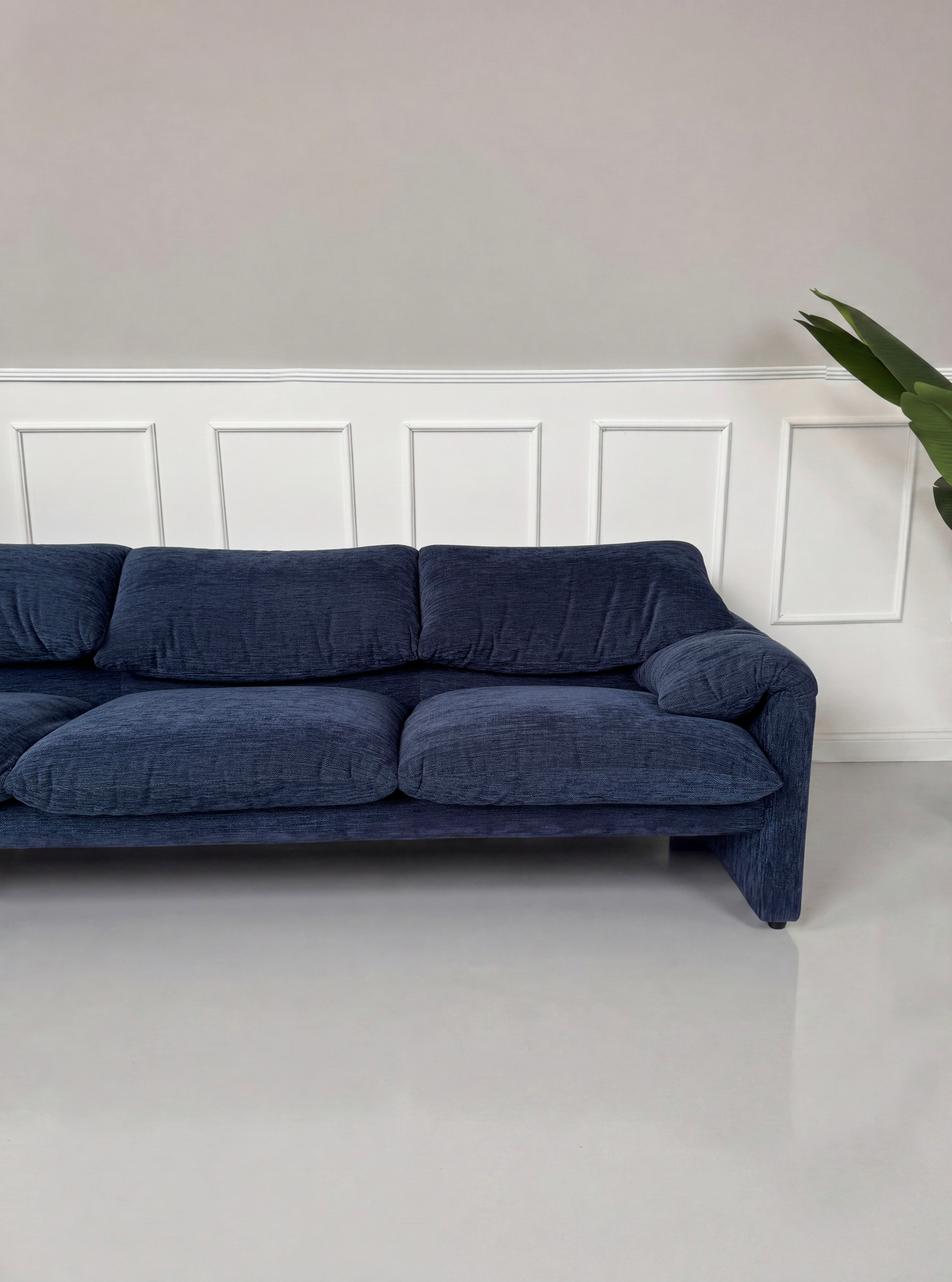 Gebrauchtes blaues Cassina Maralunga Designer Stoff Sofa vor einer Wand, stilvoll und modern eingerichtet.
