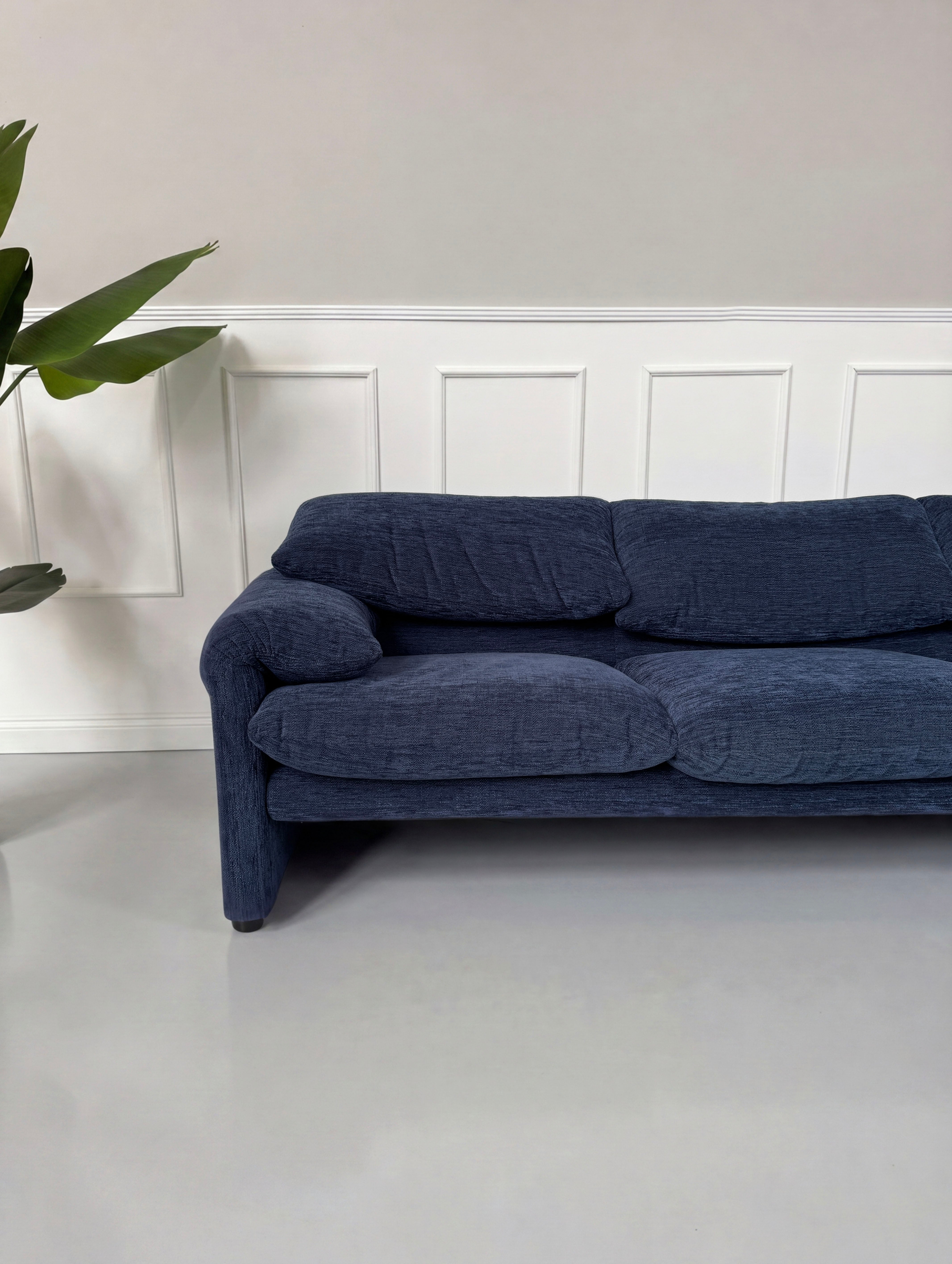 Gebrauchtes blaues Cassina Maralunga Designer Stoff Sofa vor einer Wand, stilvoll und modern eingerichtet.
