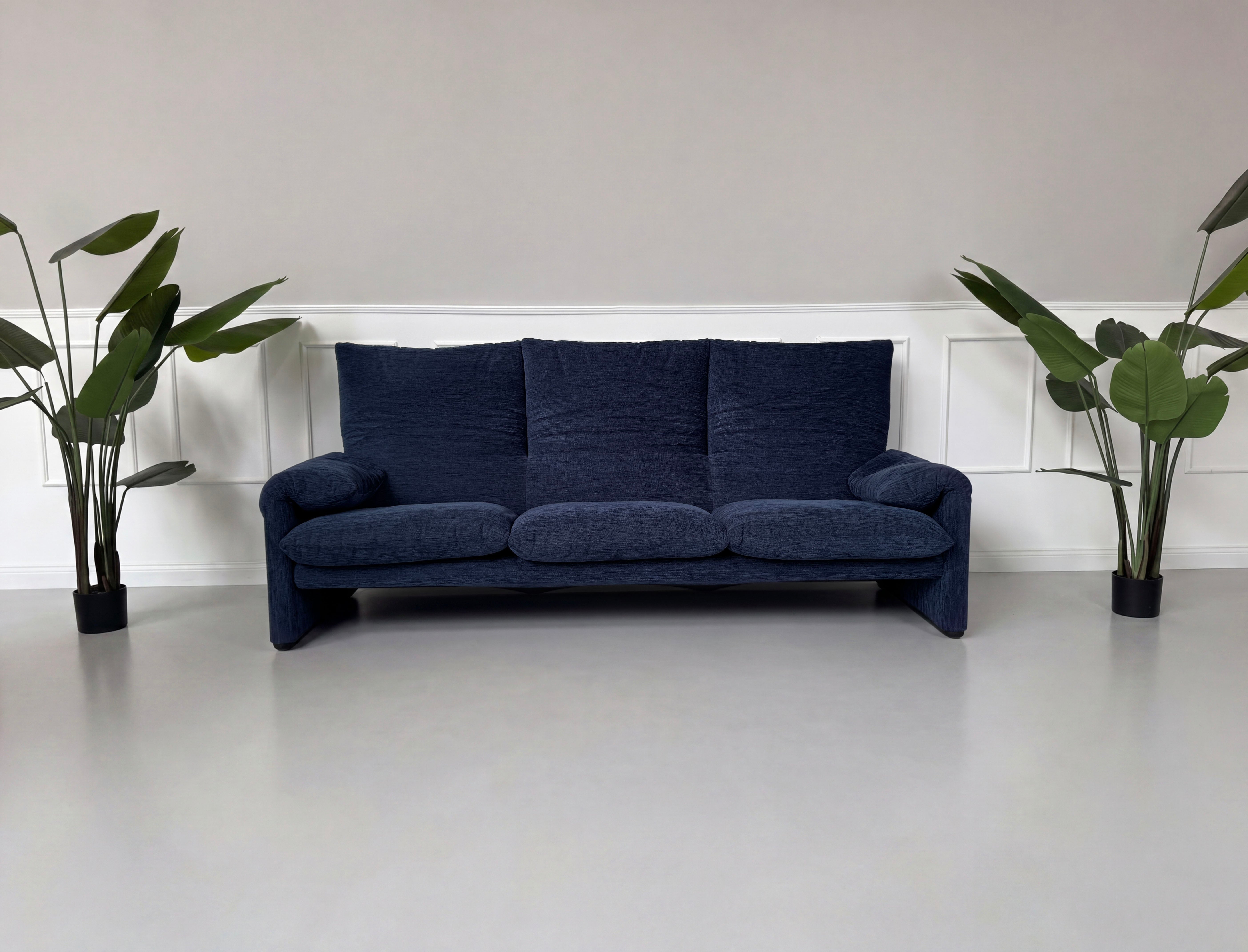 Gebrauchtes blaues Cassina Maralunga Designer Stoff Sofa vor einer Wand, stilvoll und modern eingerichtet.
