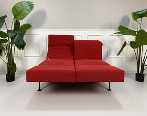 Gebrauchtes rotes Brühl Moule Small Designer Stoff Sofa vor einer Wand, stilvoll und modern eingerichtet.