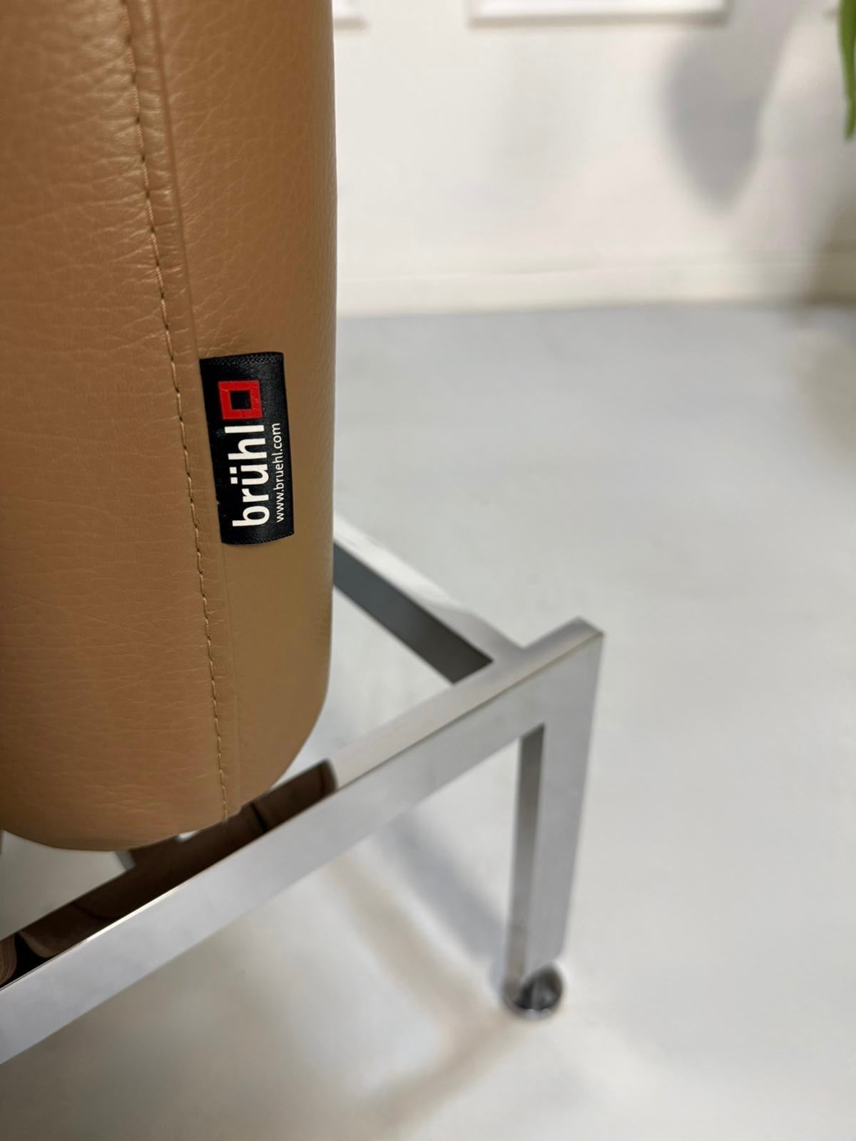 Gebrauchtes braunes Brühl Roro Small Designer Leder Sofa vor einer Wand, stilvoll und modern eingerichtet.