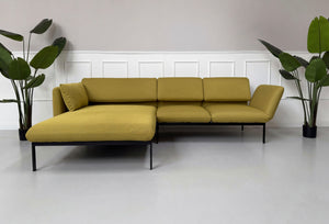 Gebrauchtes gelbes Brühl Roro Designer Stoff Sofa vor einer Wand, stilvoll und modern eingerichtet.