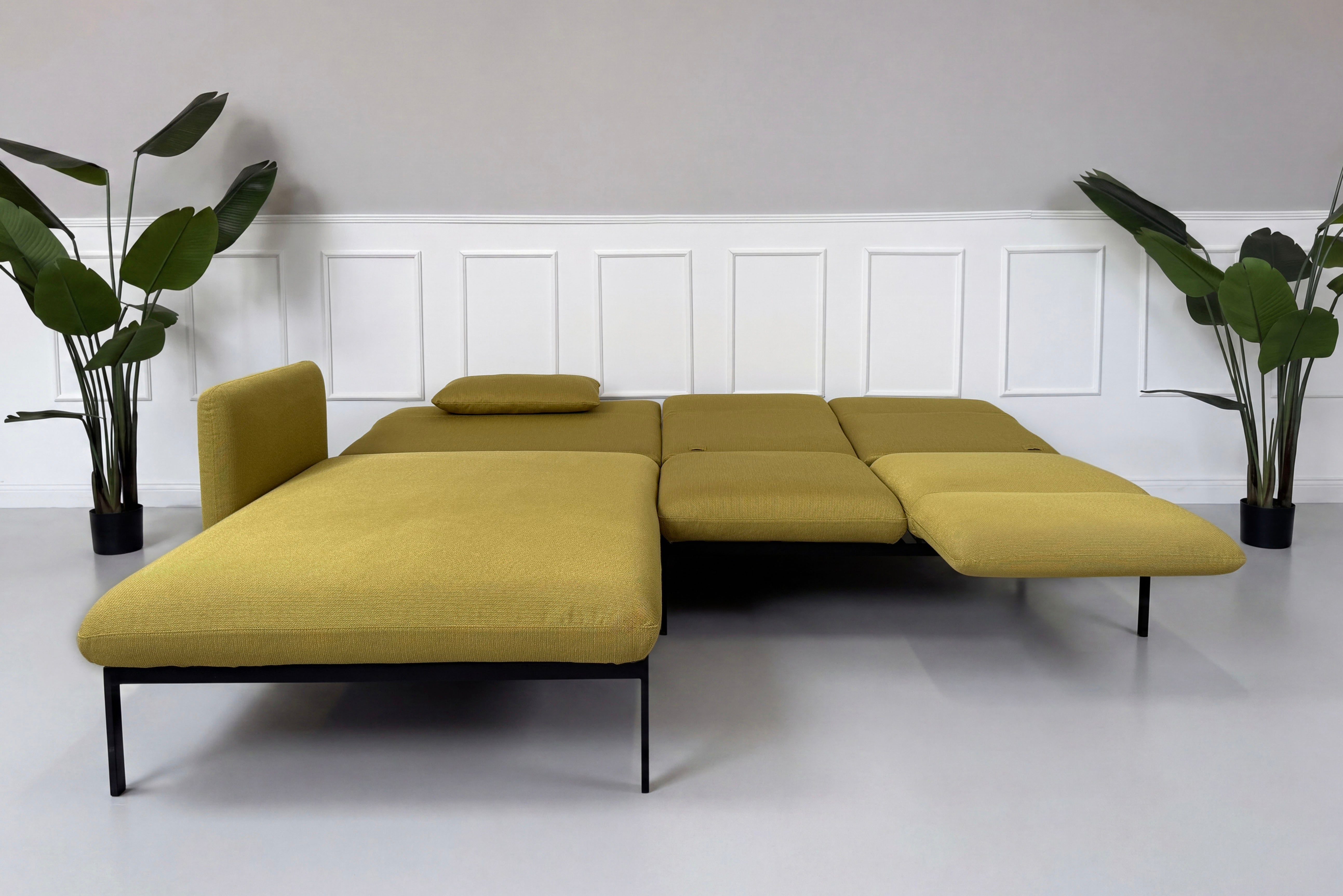 Gebrauchtes gelbes Brühl Roro Designer Stoff Sofa vor einer Wand, stilvoll und modern eingerichtet.