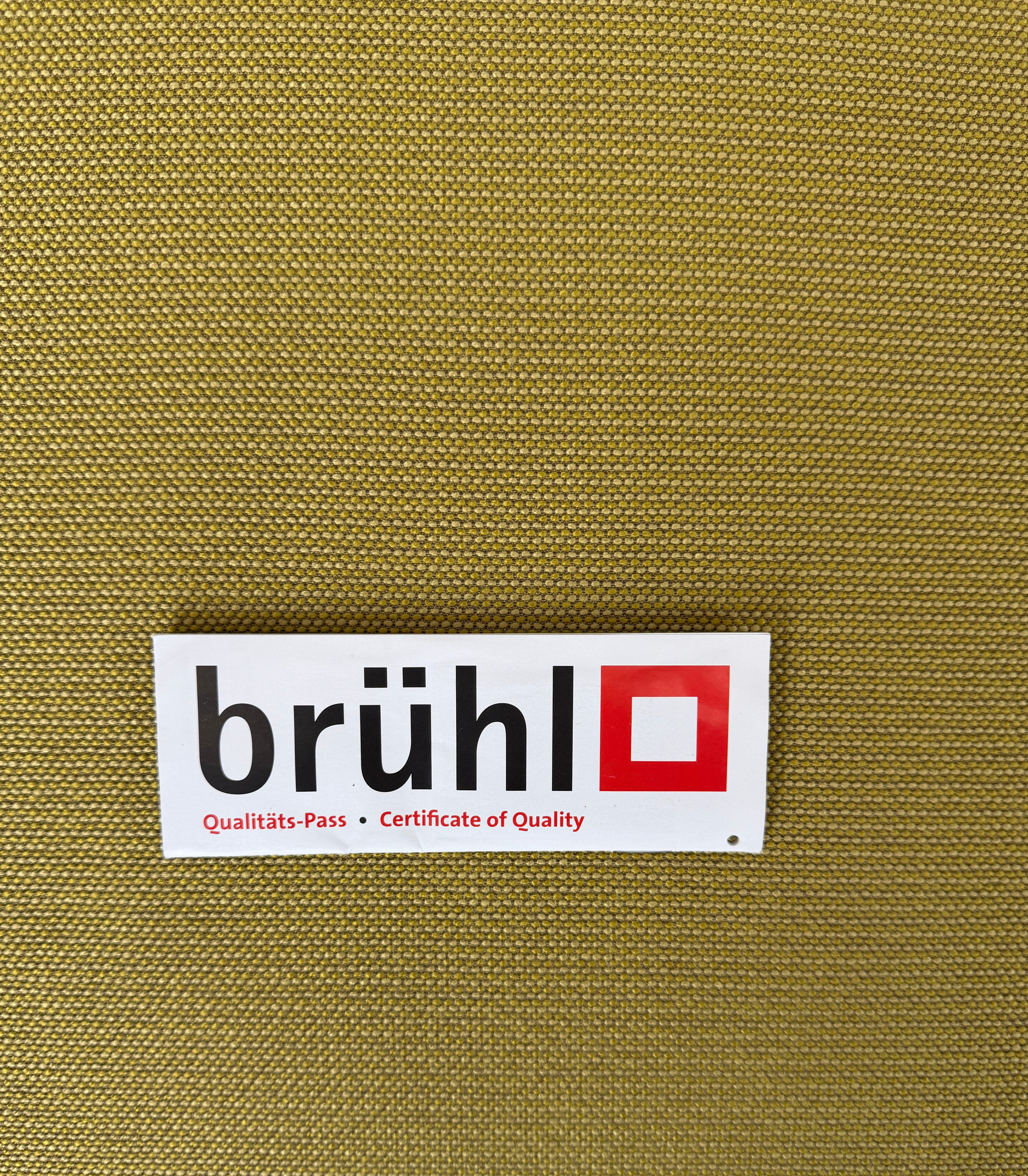 Gebrauchtes gelbes Brühl Roro Designer Stoff Sofa vor einer Wand, stilvoll und modern eingerichtet.