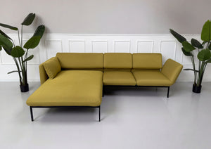 Gebrauchtes gelbes Brühl Roro Designer Stoff Sofa vor einer Wand, stilvoll und modern eingerichtet.

