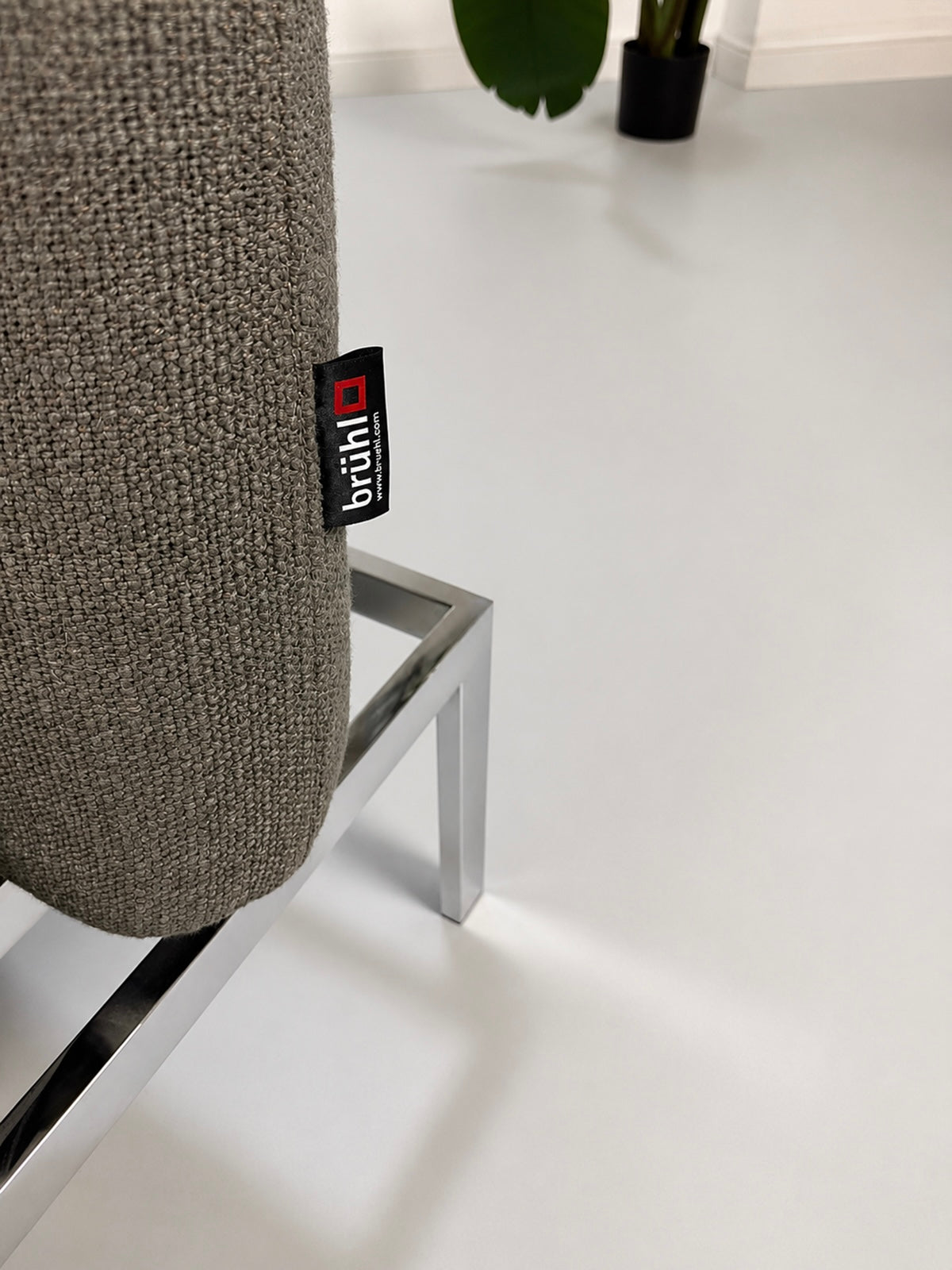 Gebrauchtes graues Brühl Roro Designer Stoff Sofa vor einer Wand, stilvoll und modern eingerichtet.