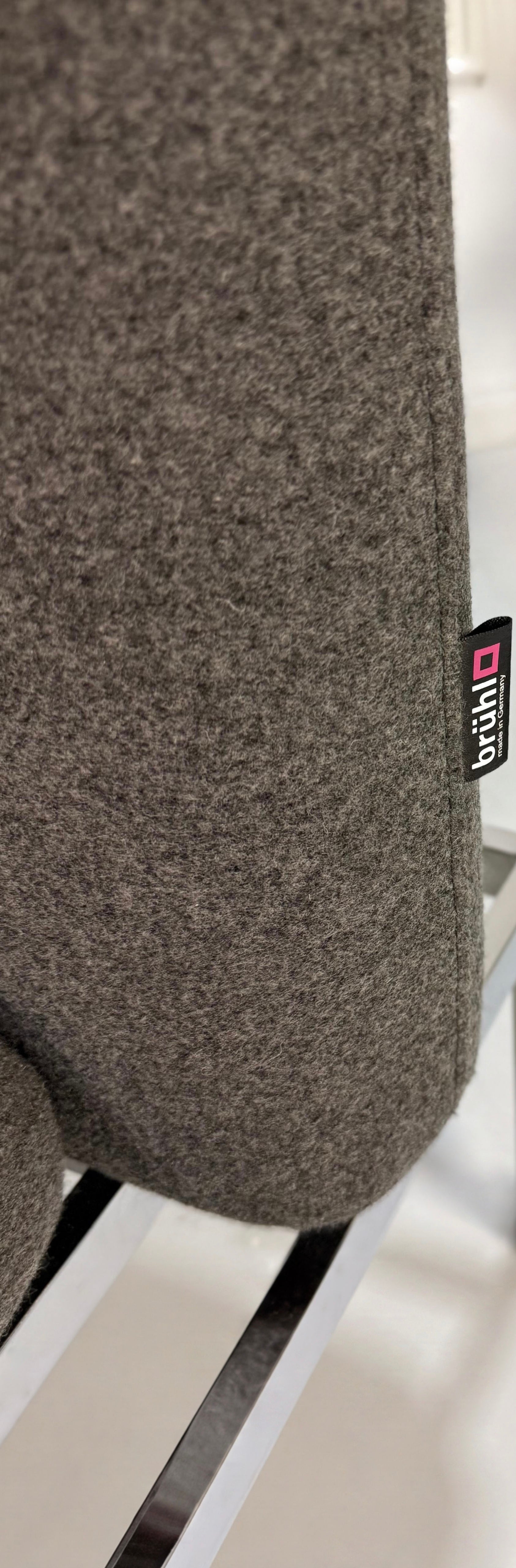 Gebrauchtes graues Brühl Roro Designer Stoff Sofa vor einer Wand, stilvoll und modern eingerichtet.