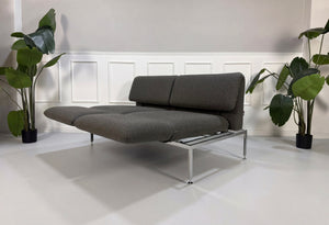 Gebrauchtes graues Brühl Roro Designer Stoff Sofa vor einer Wand, stilvoll und modern eingerichtet.