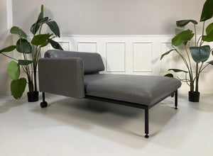 Gebrauchter grauer Brühl Roro Designer Leder Longchair vor einer Wand, stilvoll und modern eingerichtet.