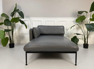 Gebrauchter grauer Brühl Roro Designer Leder Longchair vor einer Wand, stilvoll und modern eingerichtet.