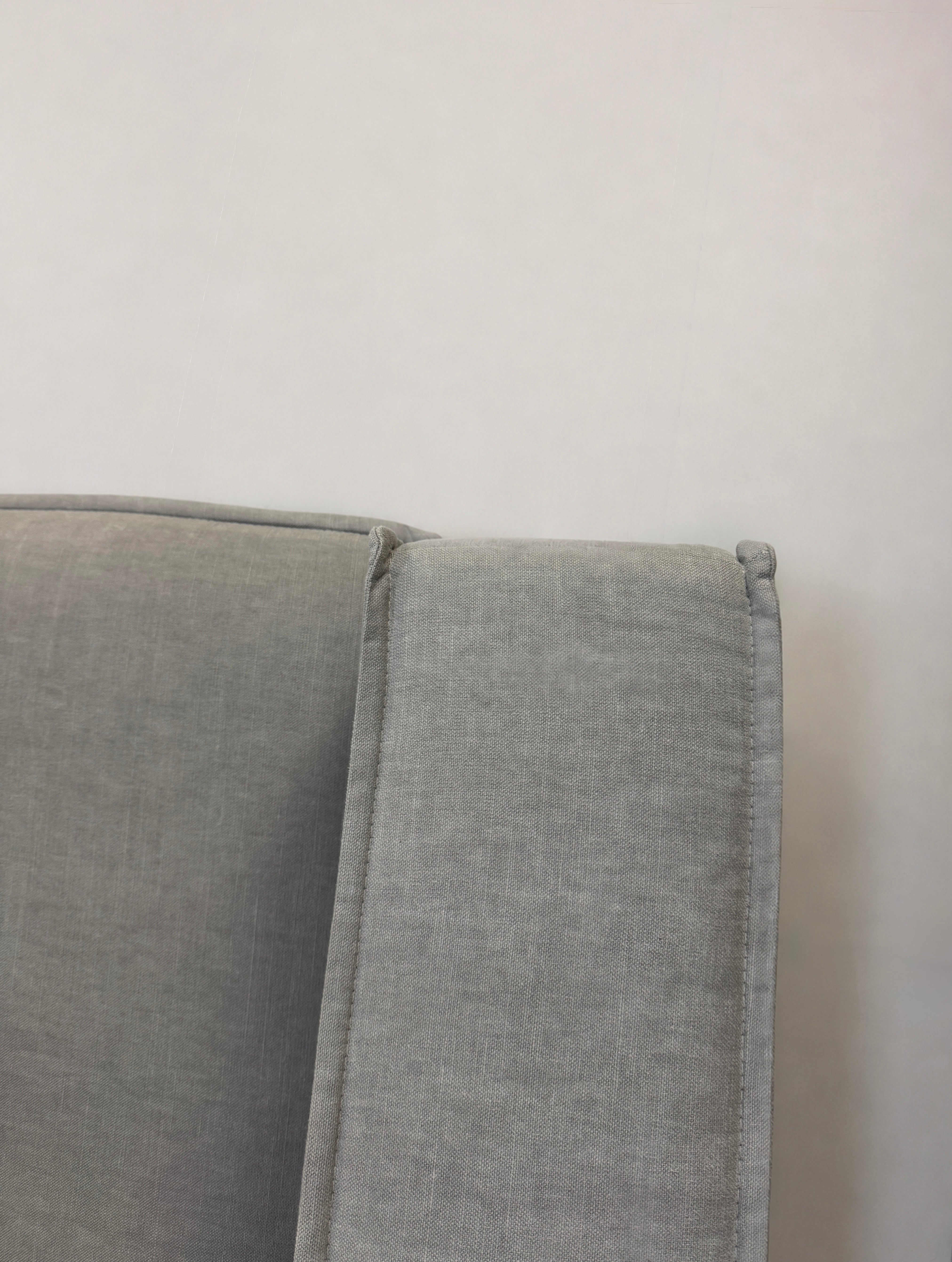 Gebrauchtes graues Bolia Noora Designer Stoff Sofa vor einer Wand, stilvoll und modern eingerichtet.