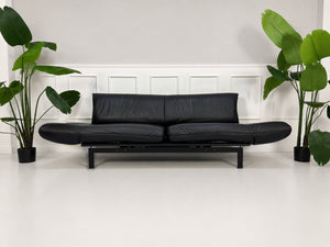 Gebrauchtes schwarzes DeSede Ds 140 Designer Leder Sofa vor einer Wand, stilvoll und modern eingerichtet.