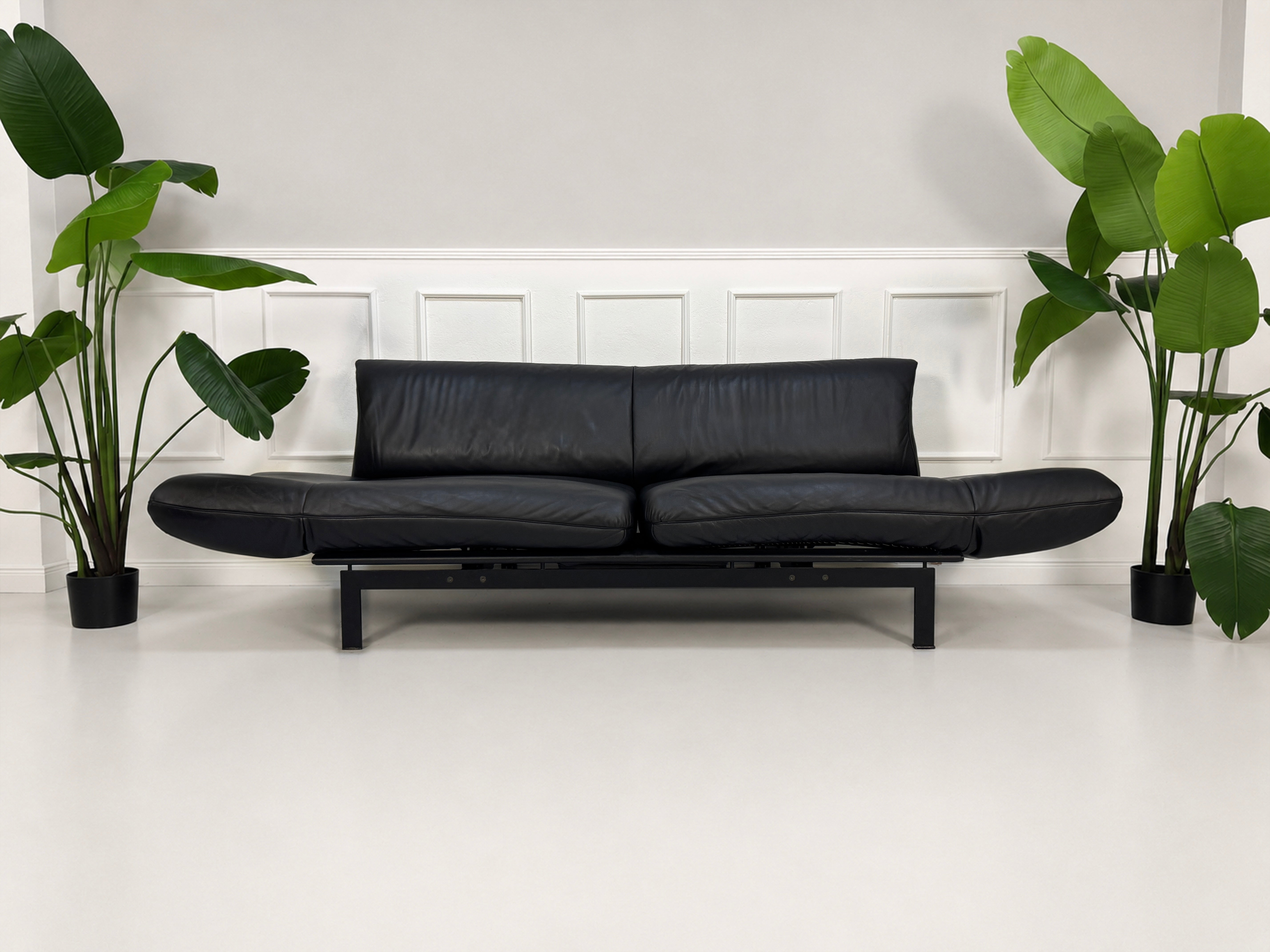 Gebrauchtes schwarzes DeSede Ds 140 Designer Leder Sofa vor einer Wand, stilvoll und modern eingerichtet.