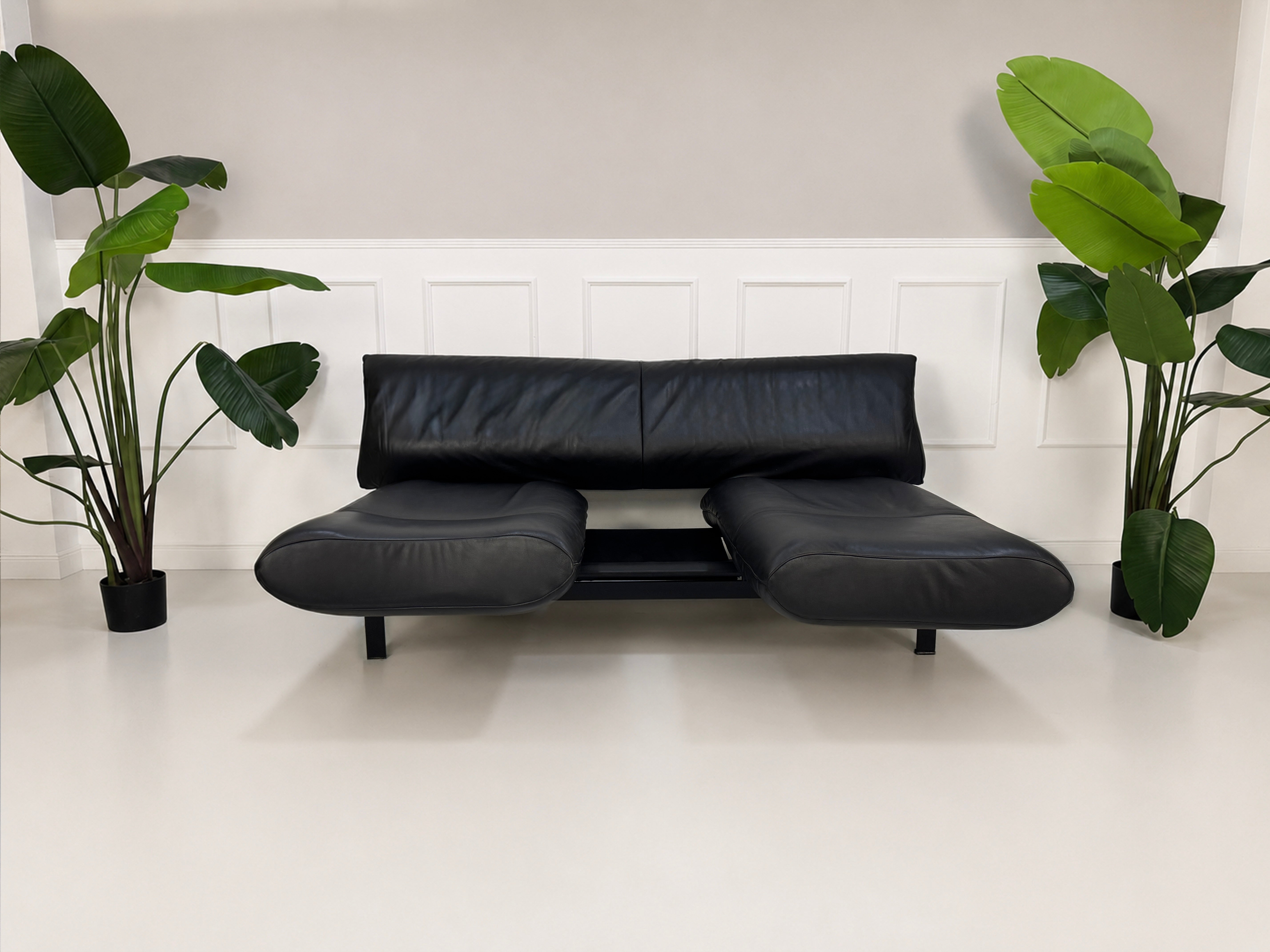 Gebrauchtes schwarzes DeSede Ds 140 Designer Leder Sofa vor einer Wand, stilvoll und modern eingerichtet.