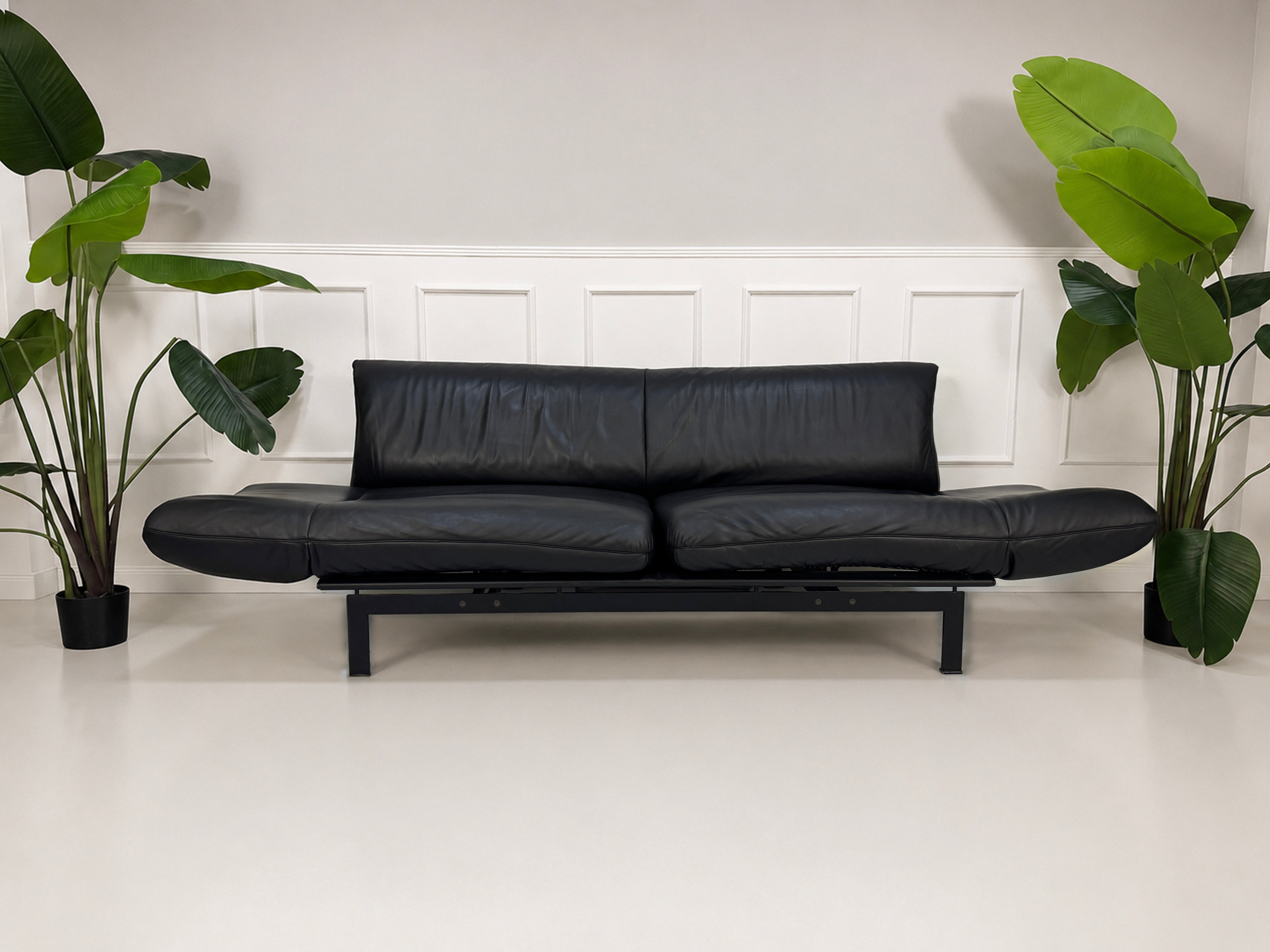 Gebrauchtes schwarzes DeSede Ds 140 Designer Leder Sofa vor einer Wand, stilvoll und modern eingerichtet.