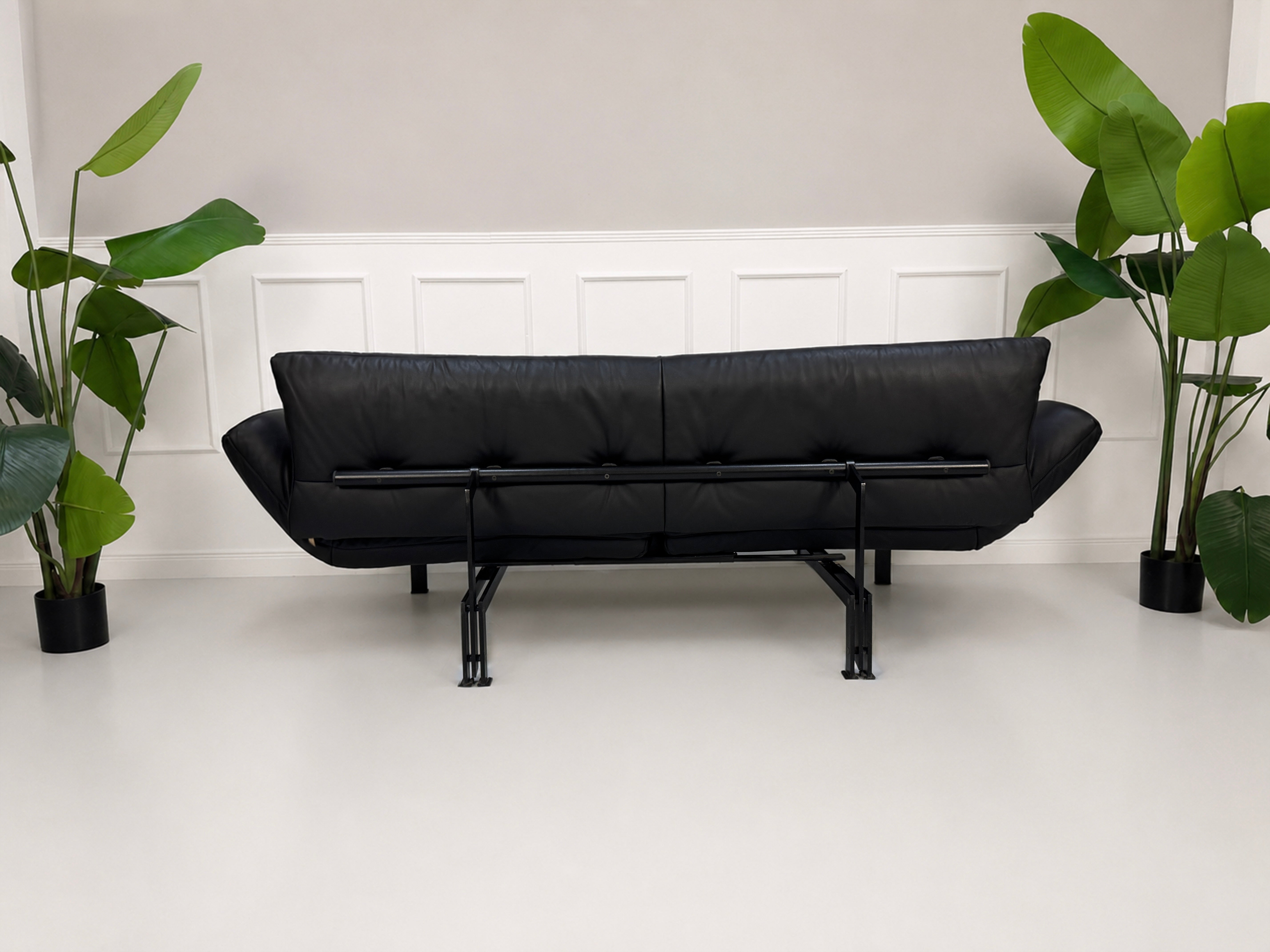 Gebrauchtes schwarzes DeSede Ds 140 Designer Leder Sofa vor einer Wand, stilvoll und modern eingerichtet.