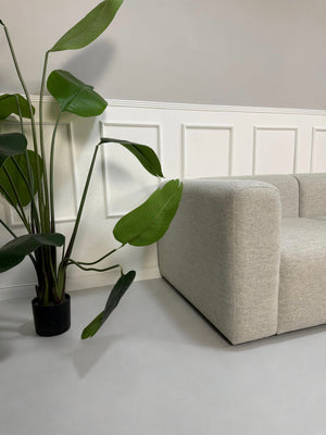 Gebrauchtes graues Hay Mags Designer Stoff Sofa vor einer Wand, stilvoll und modern eingerichtet.