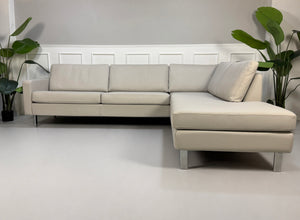 Gebrauchtes graues COR Conseta Designer Leder Sofa vor einer Wand, stilvoll und modern eingerichtet.