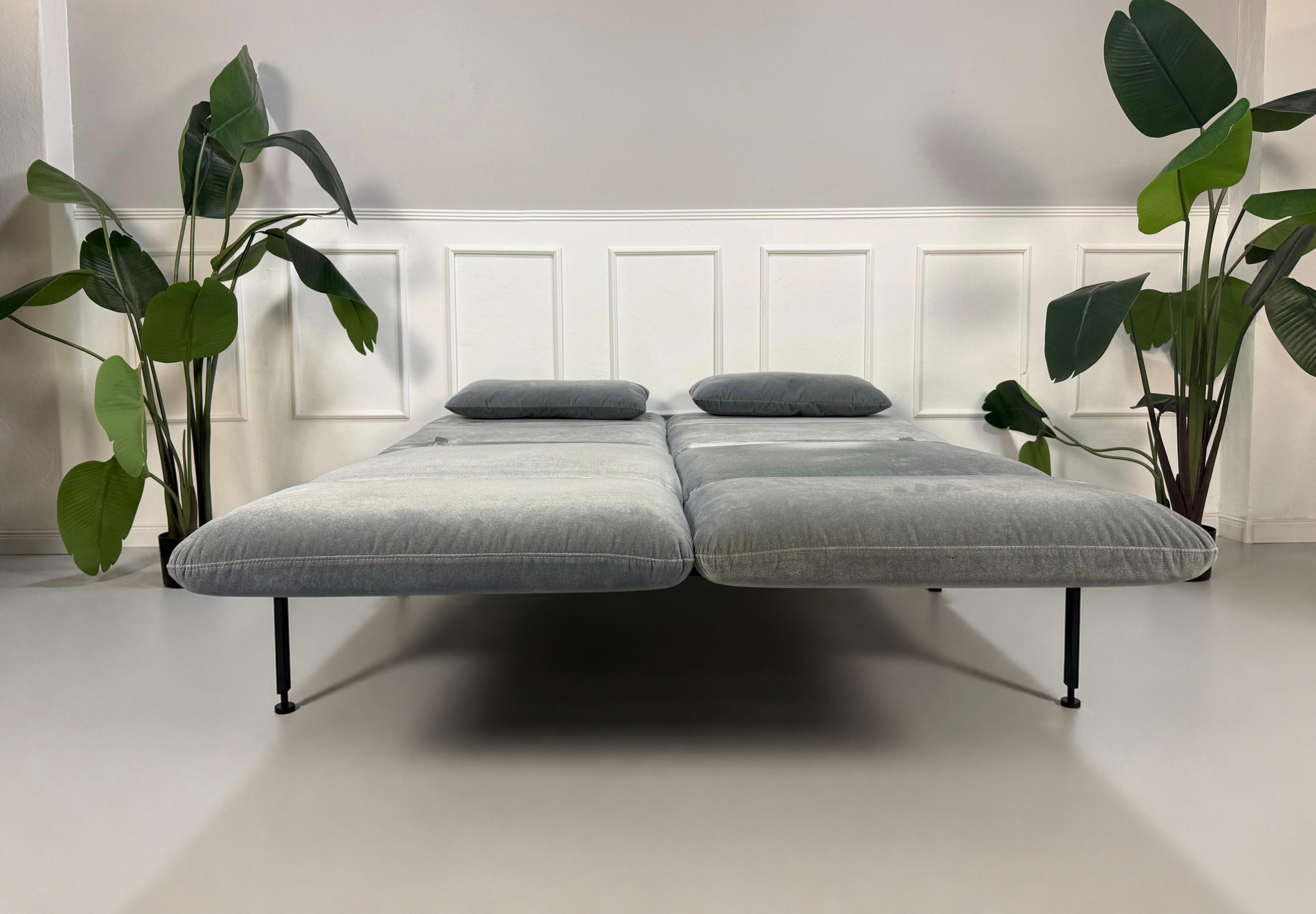 Gebrauchtes graues Brühl Roro Designer Stoff Sofa vor einer Wand, stilvoll und modern eingerichtet.