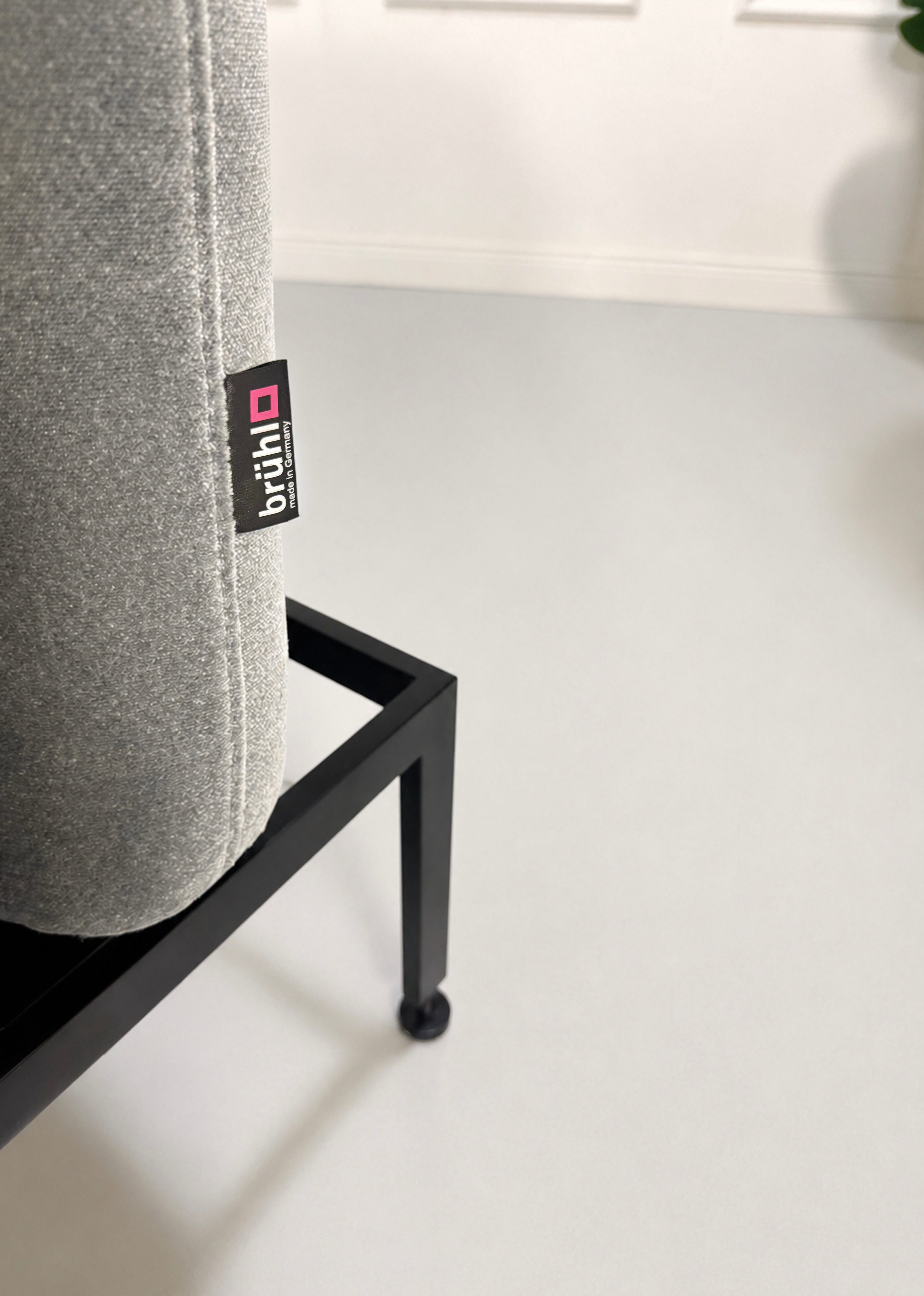 Gebrauchtes graues Brühl Roro Designer Stoff Sofa vor einer Wand, stilvoll und modern eingerichtet.
