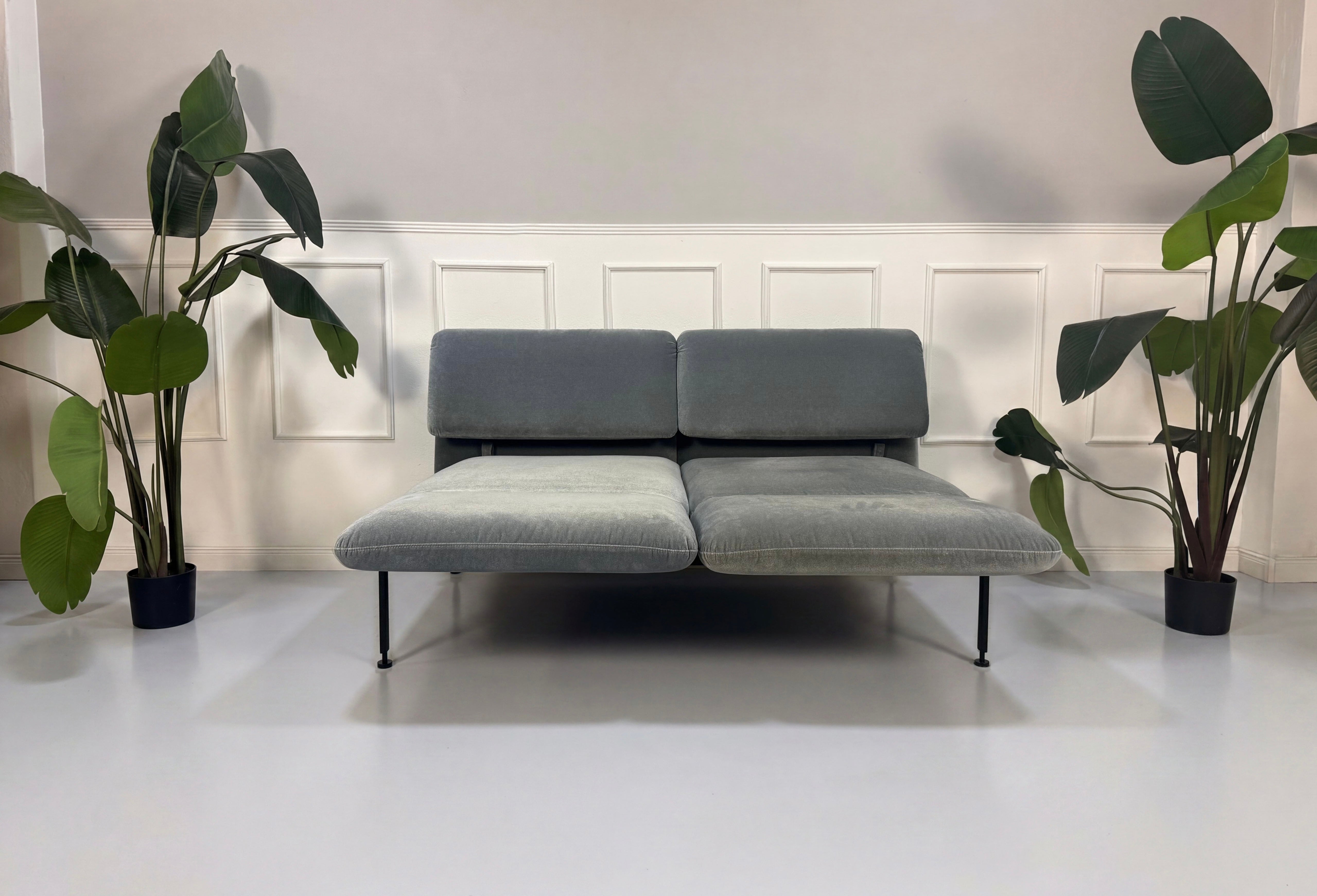 Gebrauchtes graues Brühl Roro Designer Stoff Sofa vor einer Wand, stilvoll und modern eingerichtet.