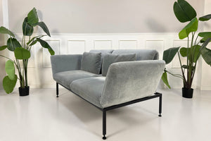 Gebrauchtes graues Brühl Roro Designer Stoff Sofa vor einer Wand, stilvoll und modern eingerichtet.