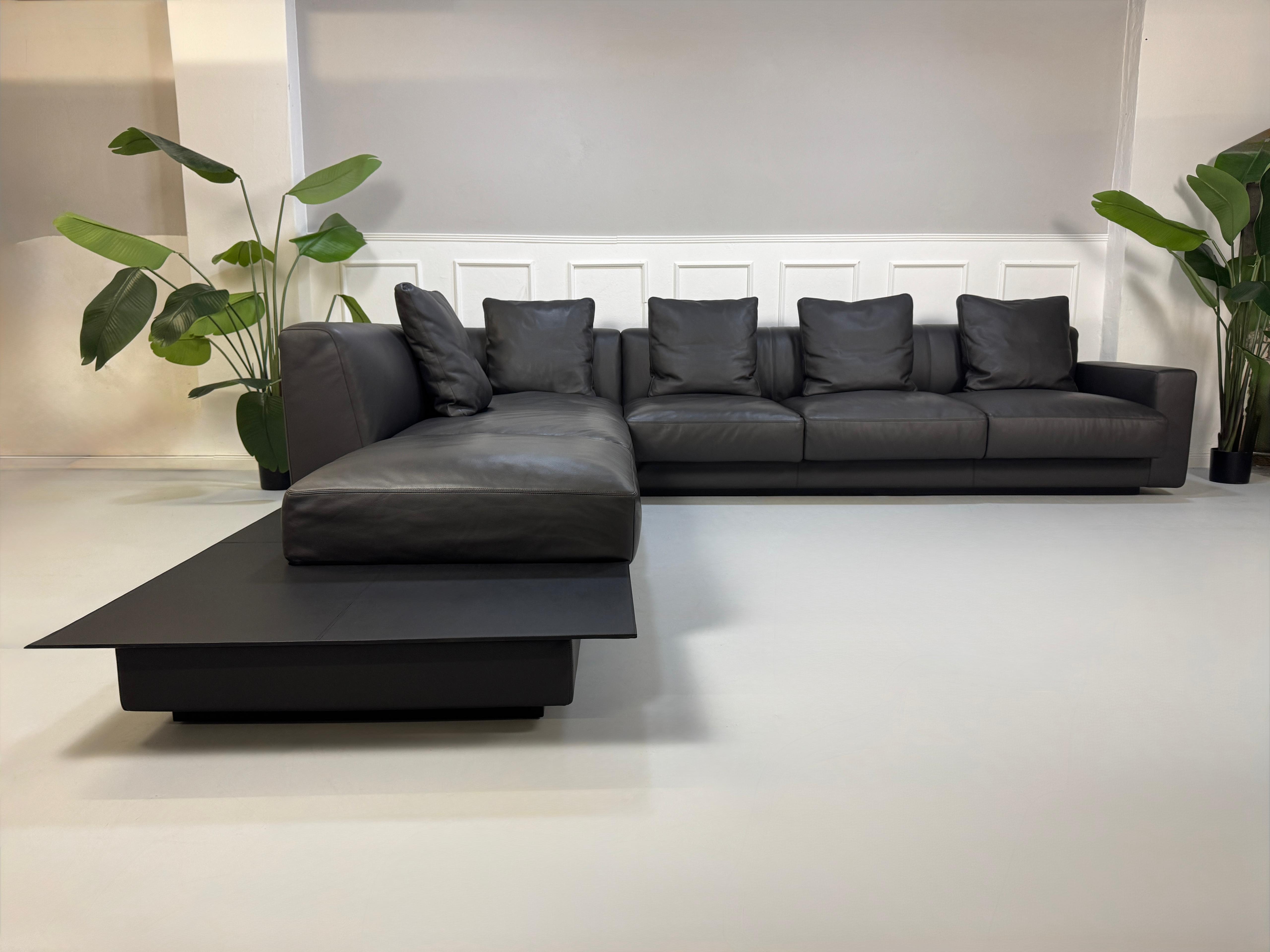 Gebrauchtes schwarzes Walter Knoll Yuuto Designer Leder Sofa vor einer Wand, stilvoll und modern eingerichtet.