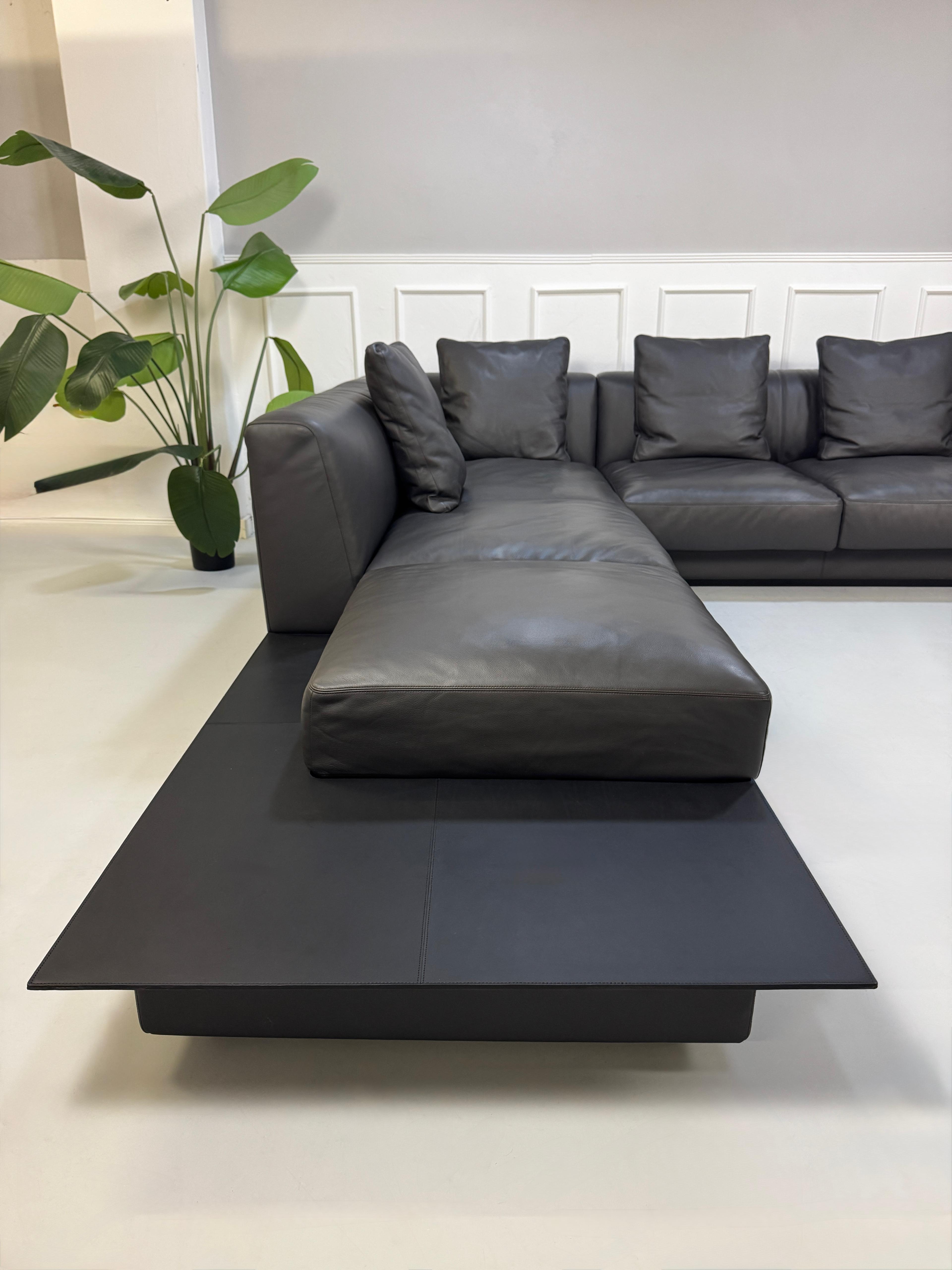 Gebrauchtes schwarzes Walter Knoll Yuuto Designer Leder Sofa vor einer Wand, stilvoll und modern eingerichtet.
