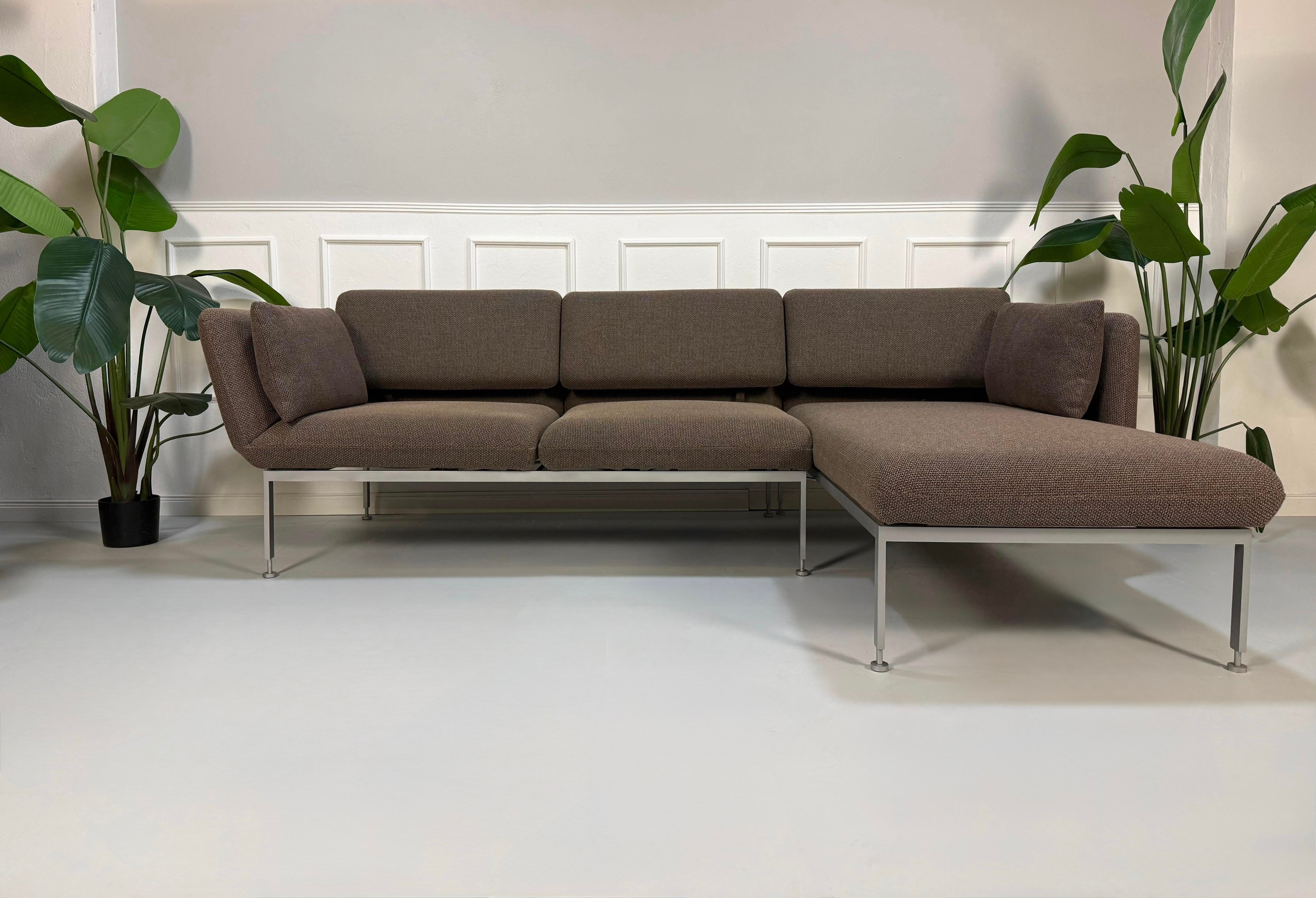 Gebrauchtes braunes Brühl Roro Designer Stoff Ecksofa vor einer Wand, stilvoll und modern eingerichtet.