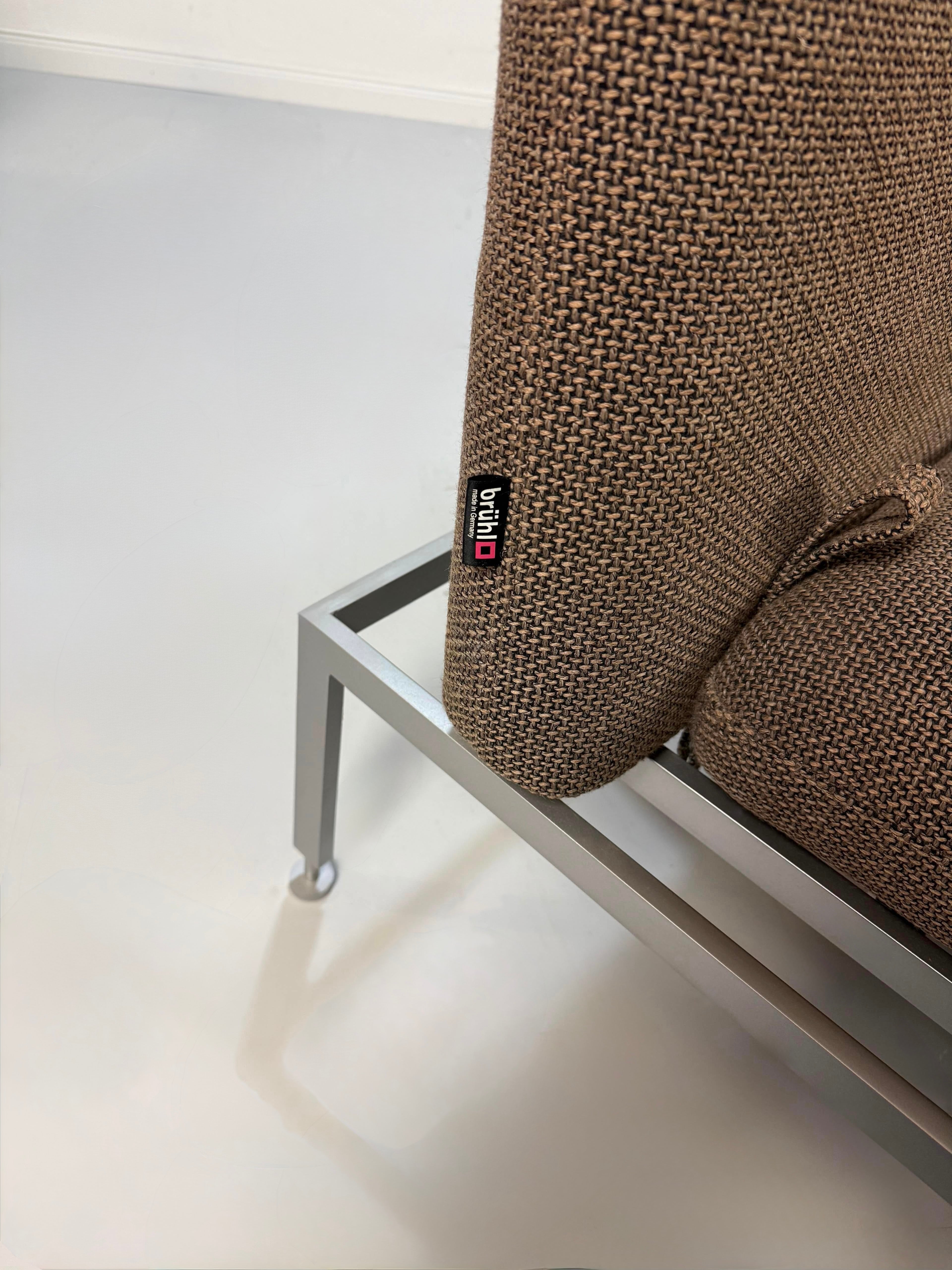 Gebrauchtes braunes Brühl Roro Designer Stoff Ecksofa vor einer Wand, stilvoll und modern eingerichtet.