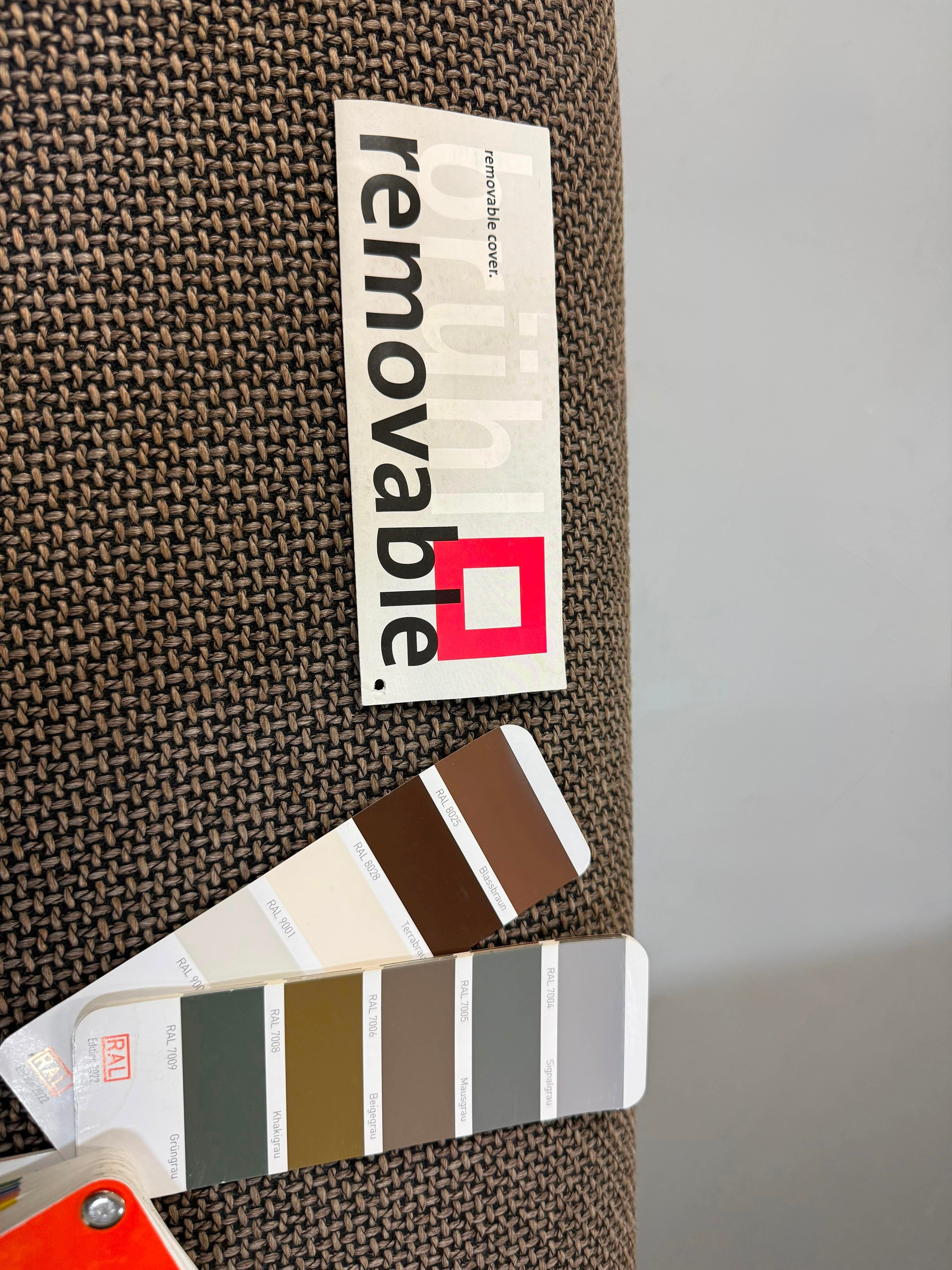 Gebrauchtes braunes Brühl Roro Designer Stoff Ecksofa vor einer Wand, stilvoll und modern eingerichtet.