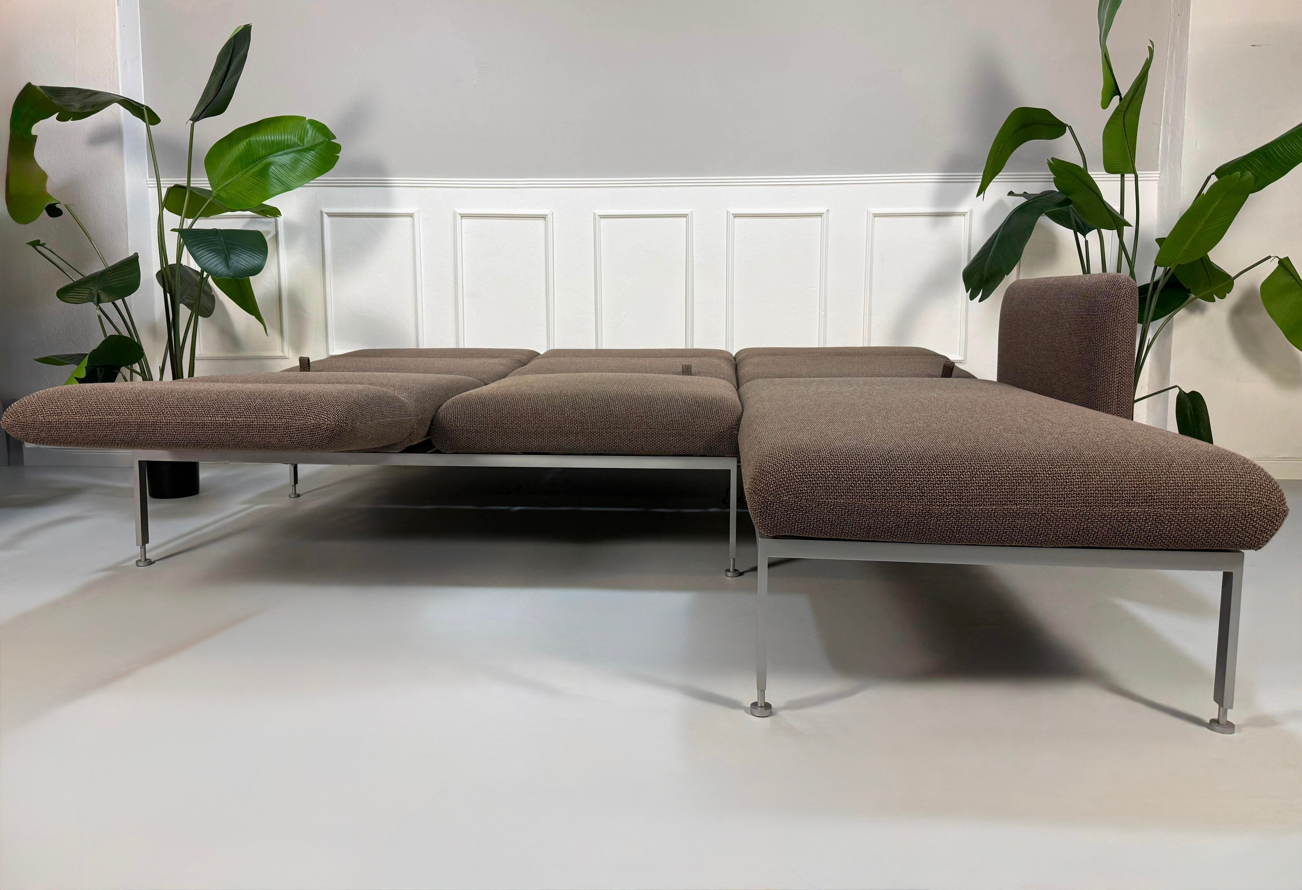 Gebrauchtes braunes Brühl Roro Designer Stoff Ecksofa vor einer Wand, stilvoll und modern eingerichtet.