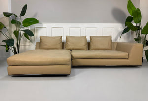 Gebrauchtes beiges Minotti Hamilton Designer Leder Sofa vor einer Wand, stilvoll und modern eingerichtet.