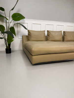 Gebrauchtes beiges Minotti Hamilton Designer Leder Sofa vor einer Wand, stilvoll und modern eingerichtet.