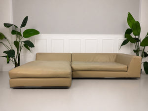 Gebrauchtes beiges Minotti Hamilton Designer Leder Sofa vor einer Wand, stilvoll und modern eingerichtet.