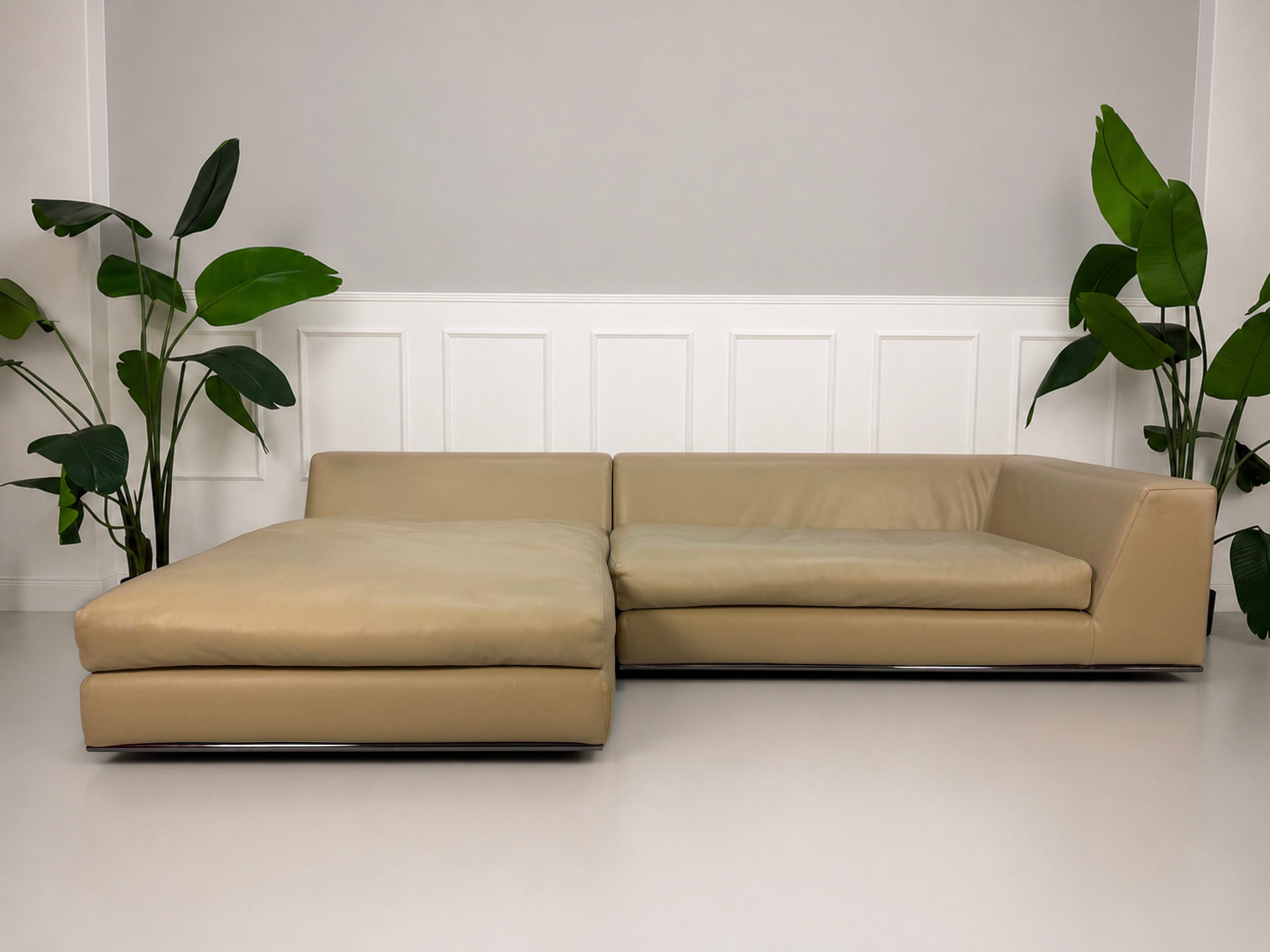 Gebrauchtes beiges Minotti Hamilton Designer Leder Sofa vor einer Wand, stilvoll und modern eingerichtet.