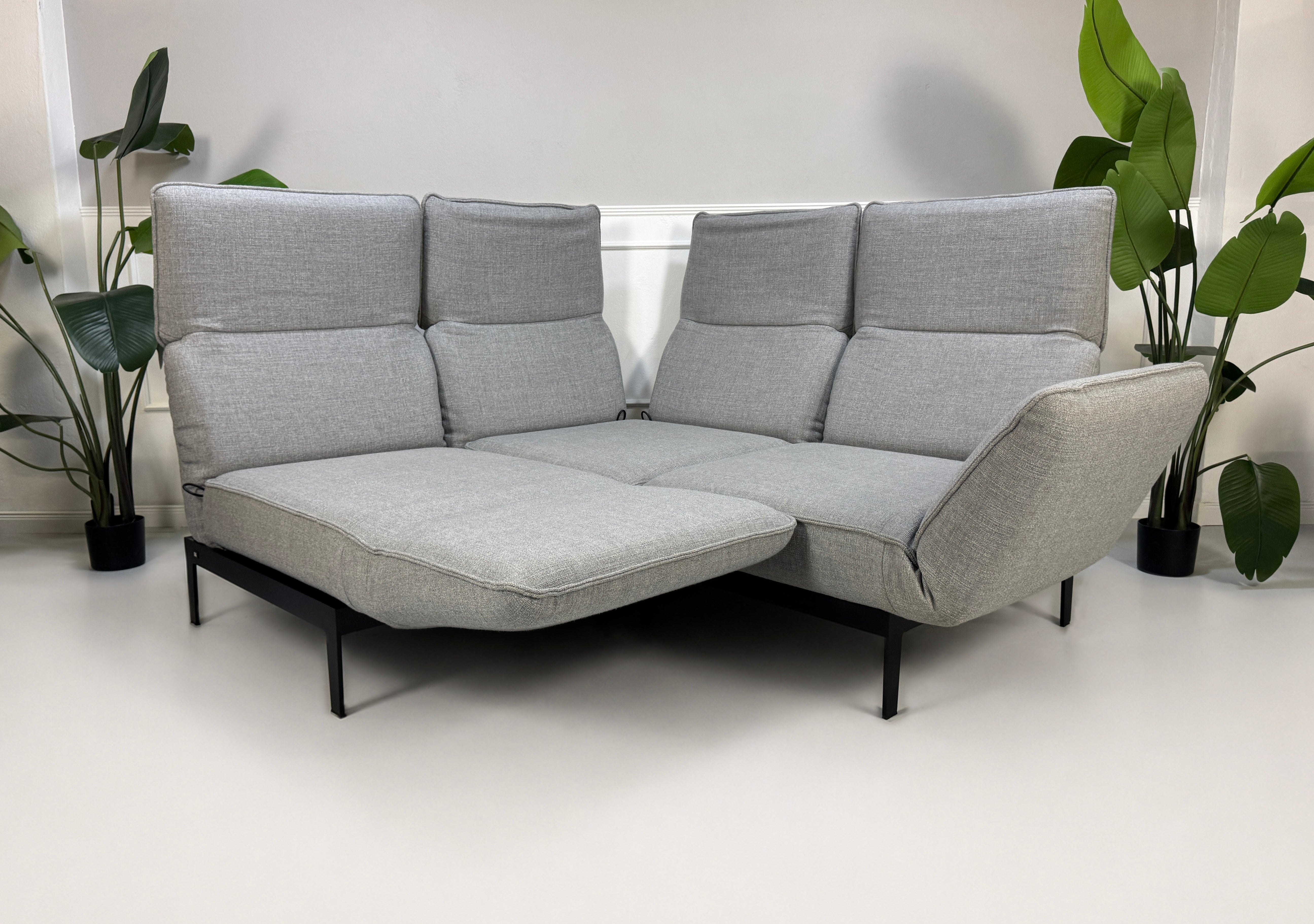 Gebrauchtes graues Rolf Benz Mera Designer Stoff Sofa vor einer Wand, stilvoll und modern eingerichtet.